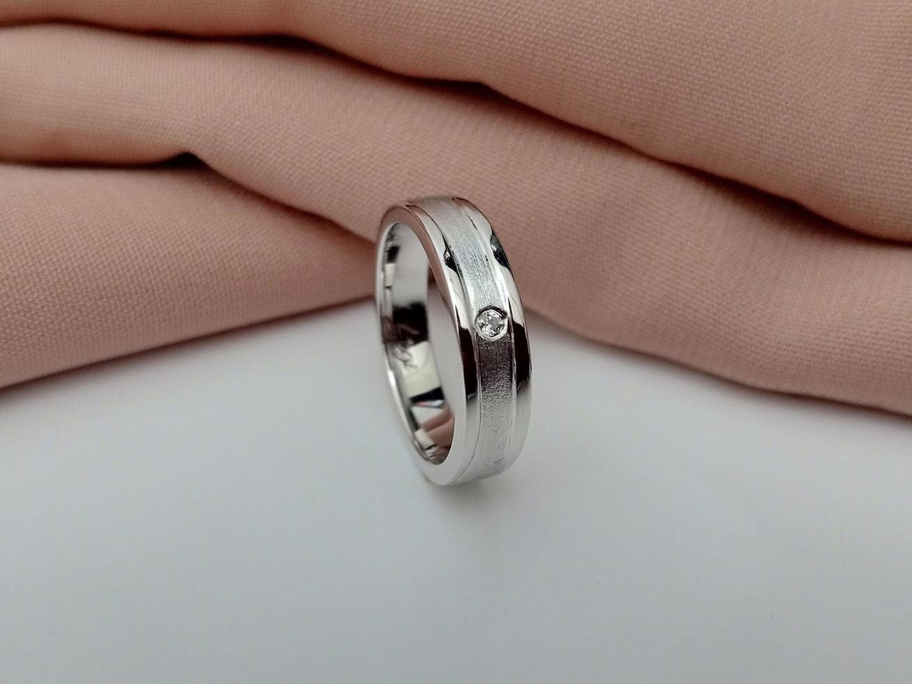 white gold wedding ring. Single ring with glossy and doff finishing with brown cloth background and white base photo