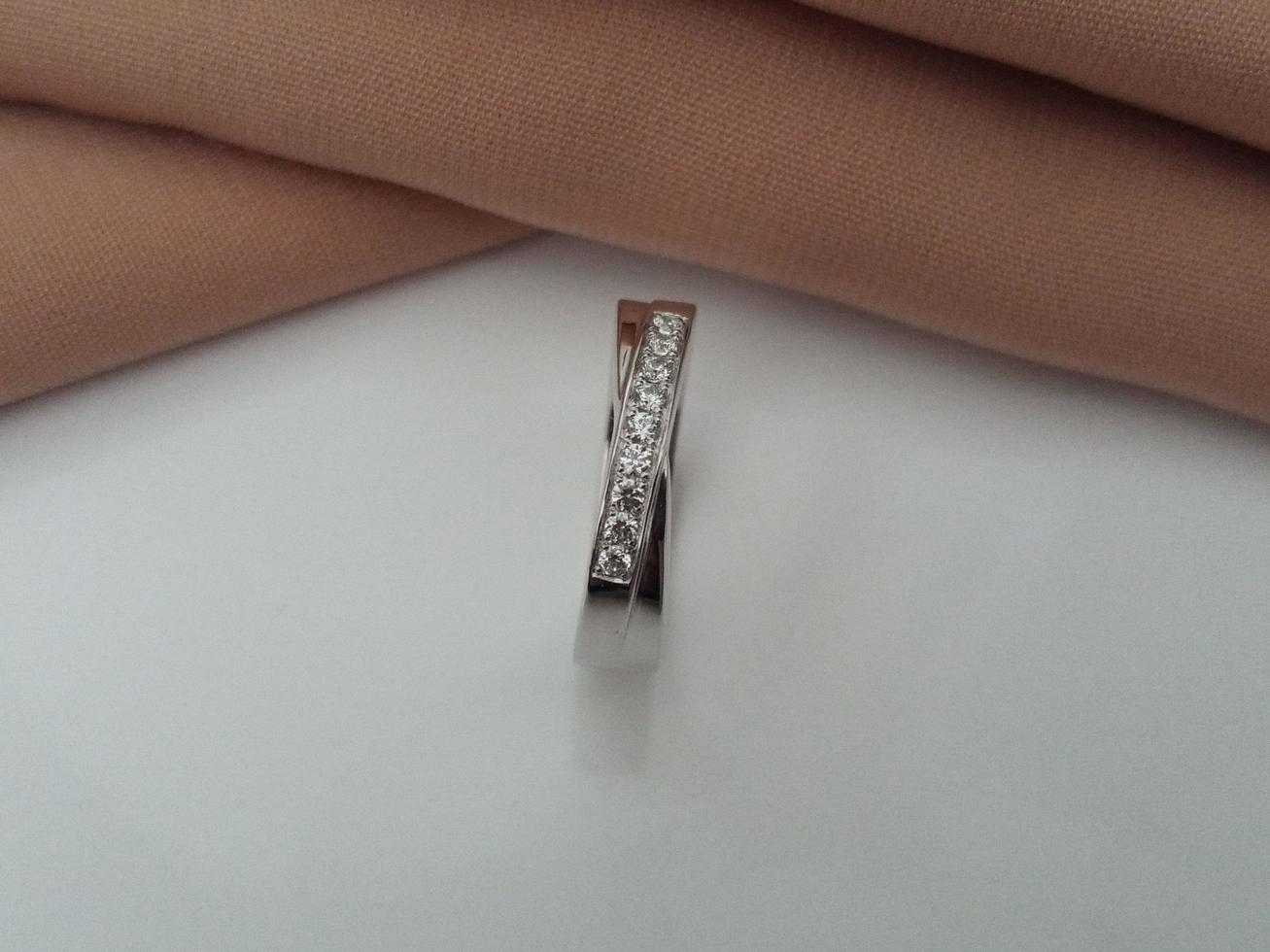 anillo de bodas de oro blanco. anillo simple con acabado brillante y apagado con fondo de tela marrón y base blanca foto