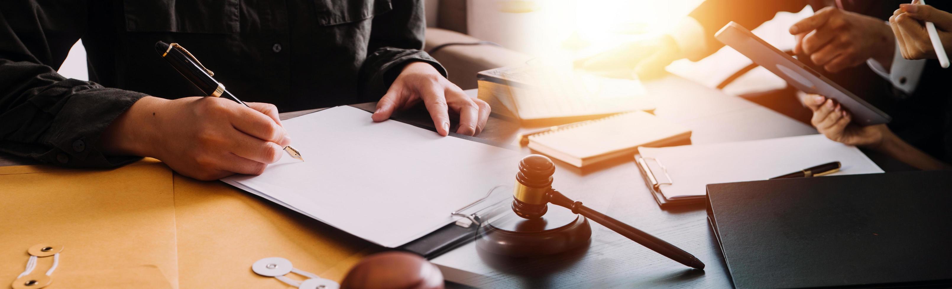 Business and lawyers discussing contract papers with brass scale on desk in office. Law, legal services, advice, justice and law concept picture with film grain effect photo