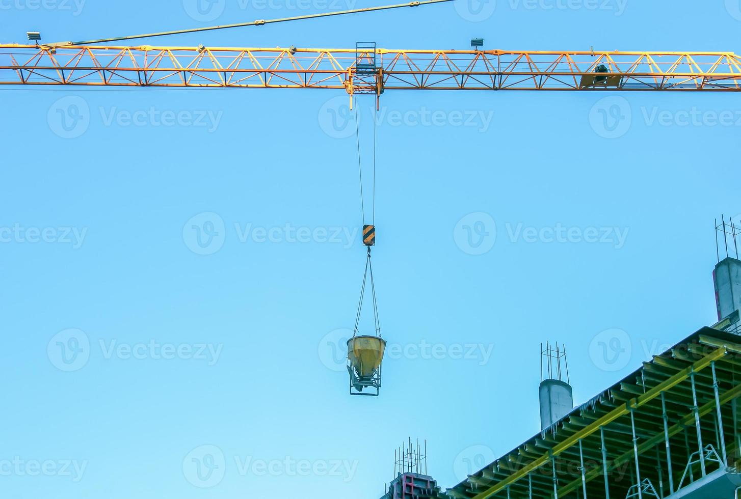 Construction crane against the blue sky. The real estate industry. A crane uses lifting equipment at a construction site. photo