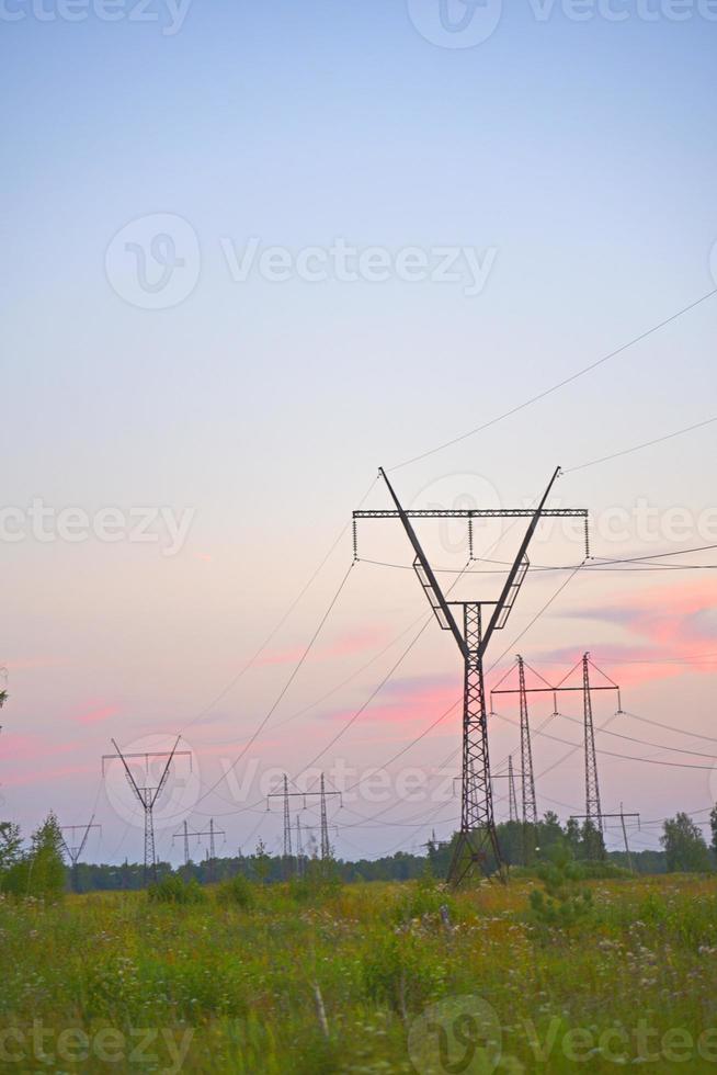 Beautiful high-voltage iron transmission line in the evening in the sunset sky. Landscape evening and wires and power lines. photo