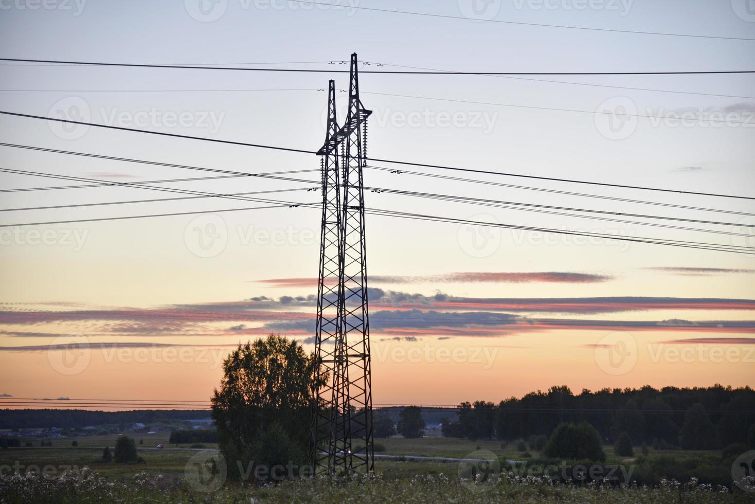 Beautiful high-voltage iron transmission line in the evening in the sunset sky. Landscape evening and wires and power lines. photo