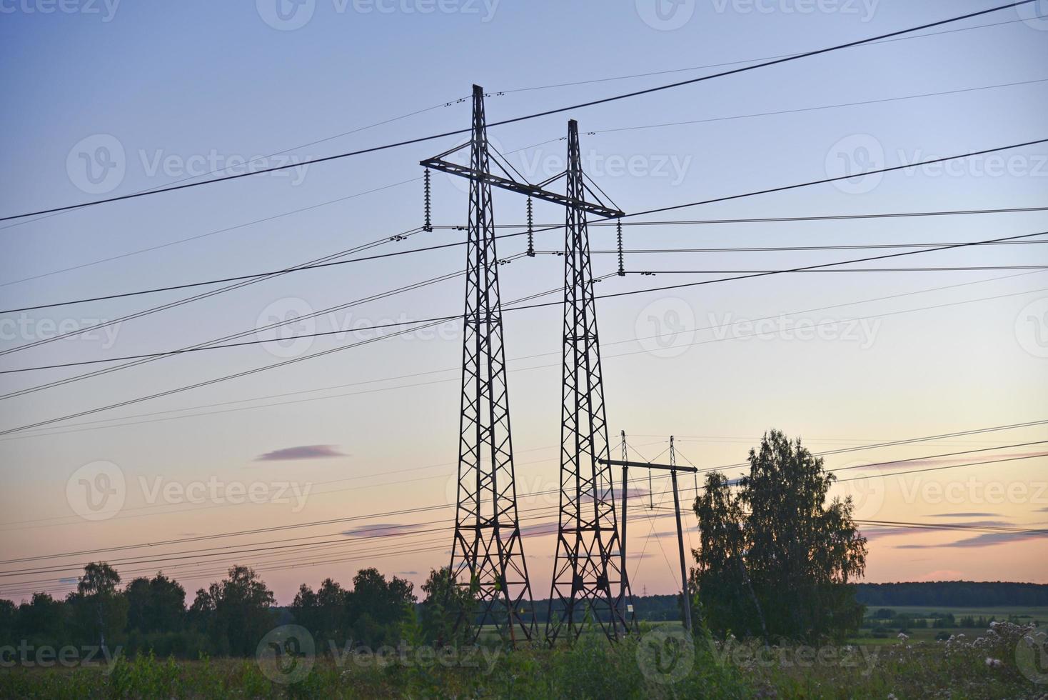 Beautiful high-voltage iron transmission line in the evening in the sunset sky. Landscape evening and wires and power lines. photo