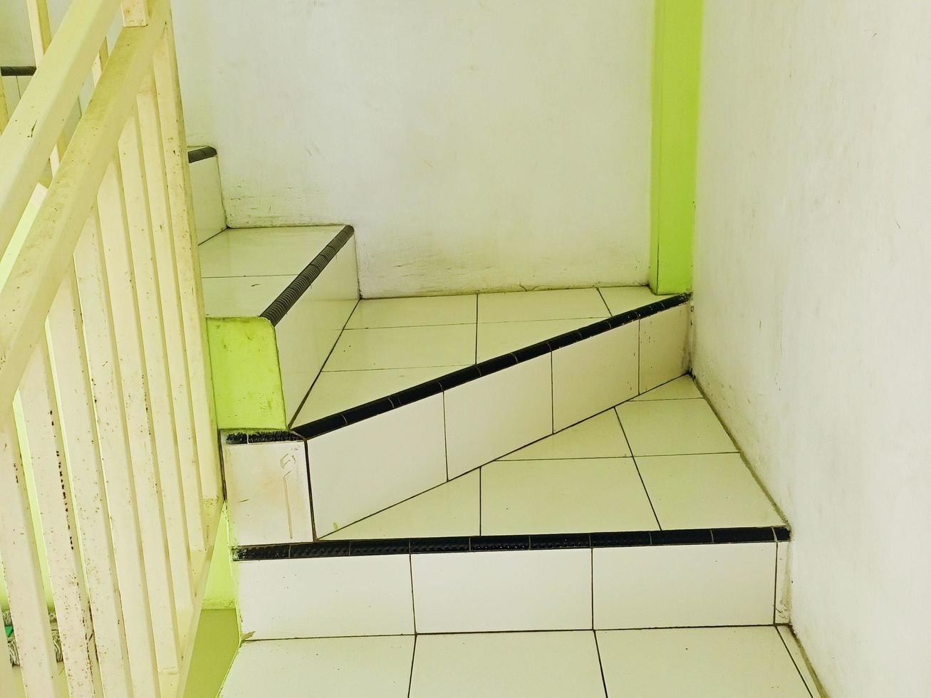 The stairs of the building in the mosque with patterned white tiled floors and white railings. Taken at noon after dhuhur prayer photo