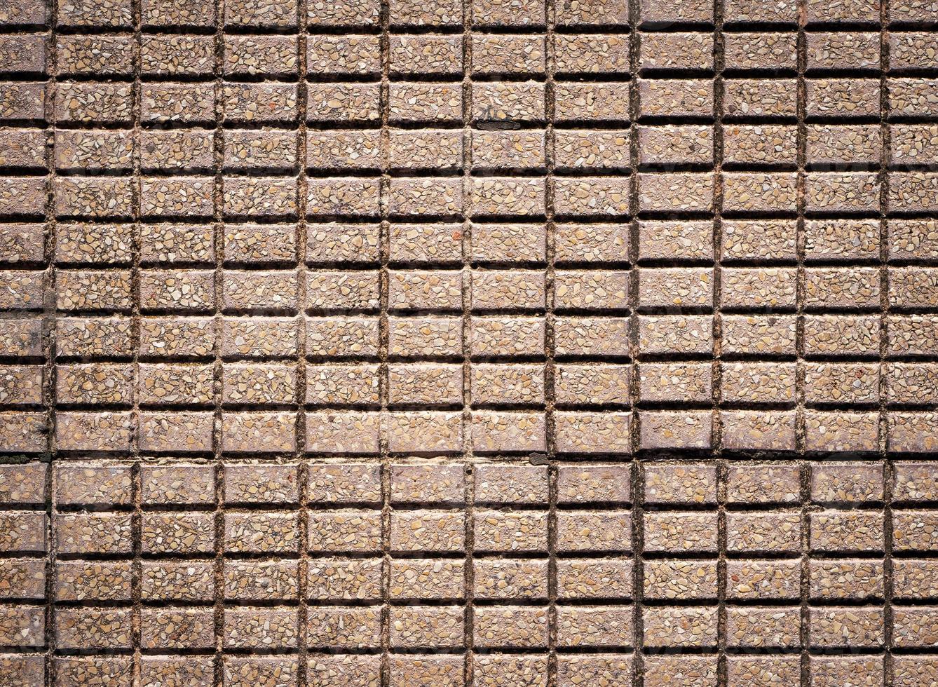 Texture of a sidewalk made from small rectangle bricks photographed from above photo