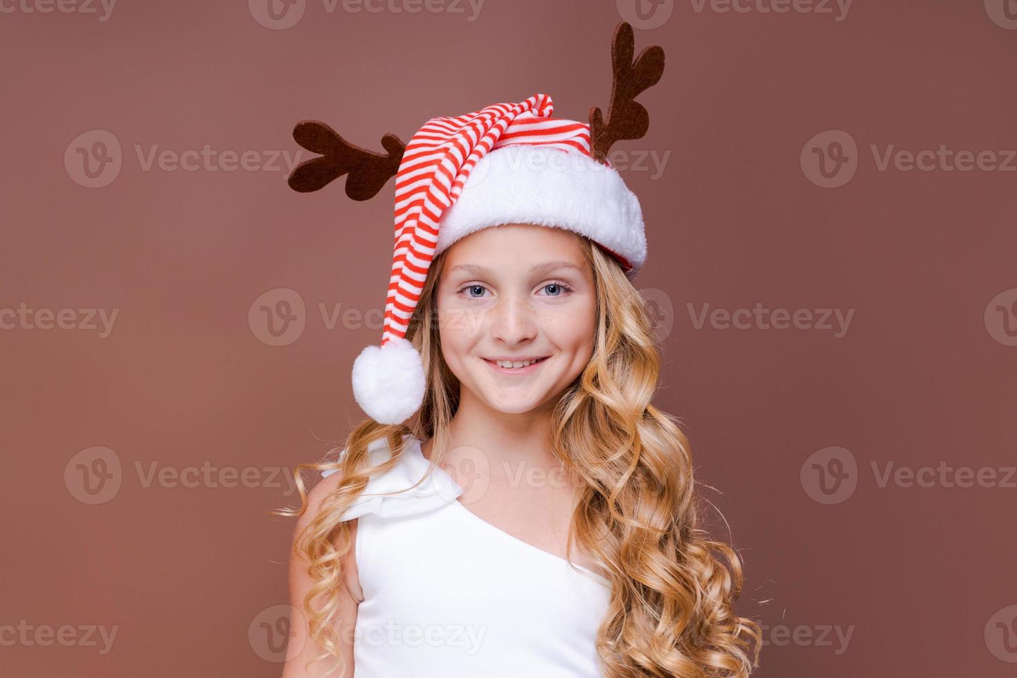 Portrait cheerful young teen girl dressed as Christmas deer standing photo