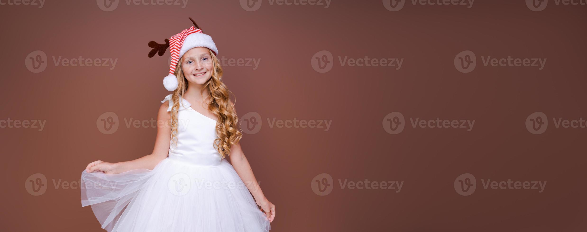 hermosa chica con sombrero con cuernos de ciervo y vestido blanco sonríe tiernamente foto