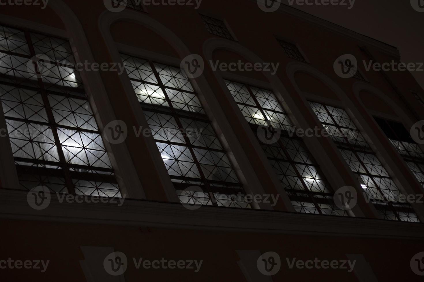 Windows at night. Light in windows in evening. Building outside in dark. photo