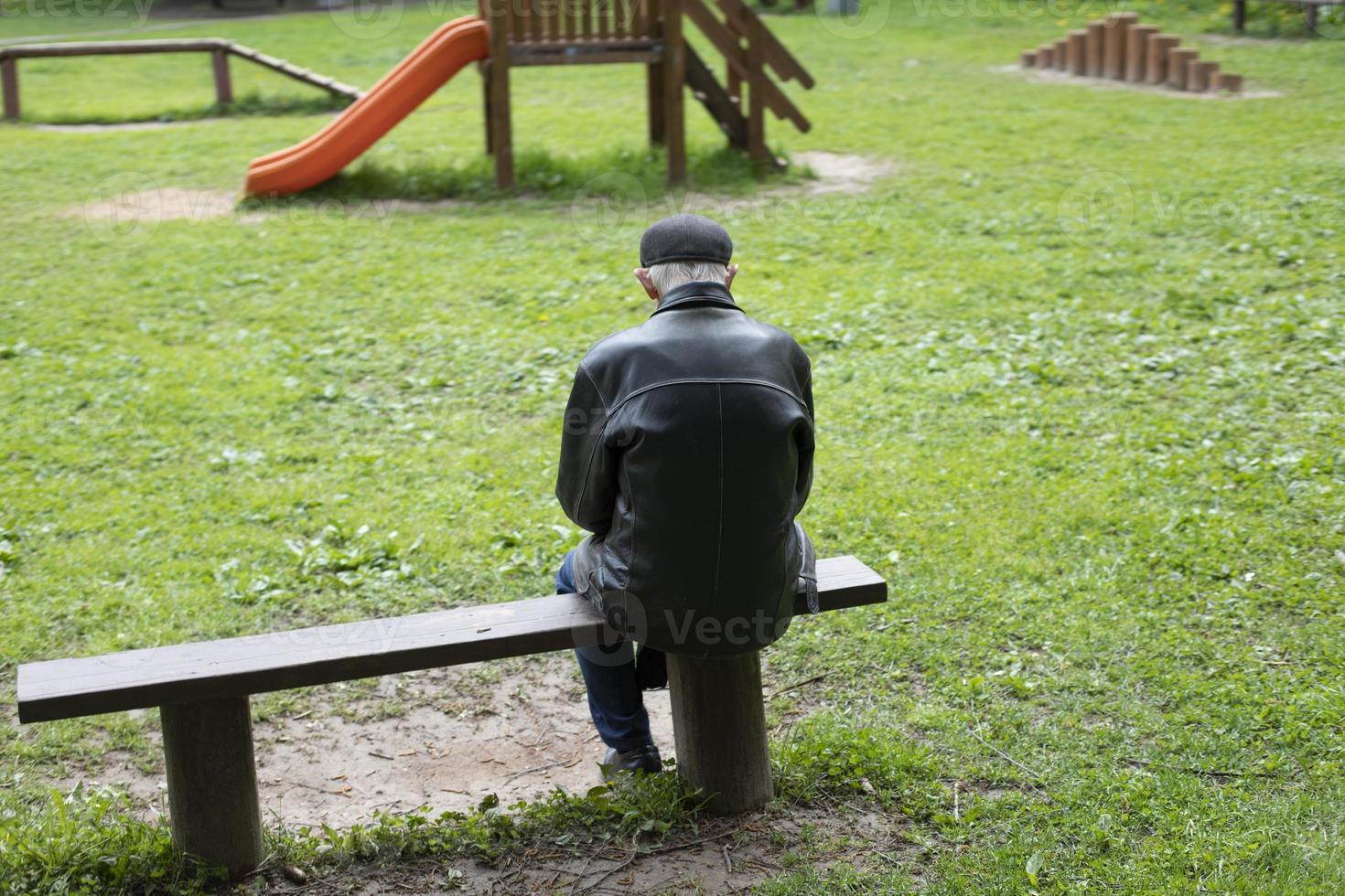 Old man sitting on bench. Elderly person in park. Pensioner rests in nature. photo