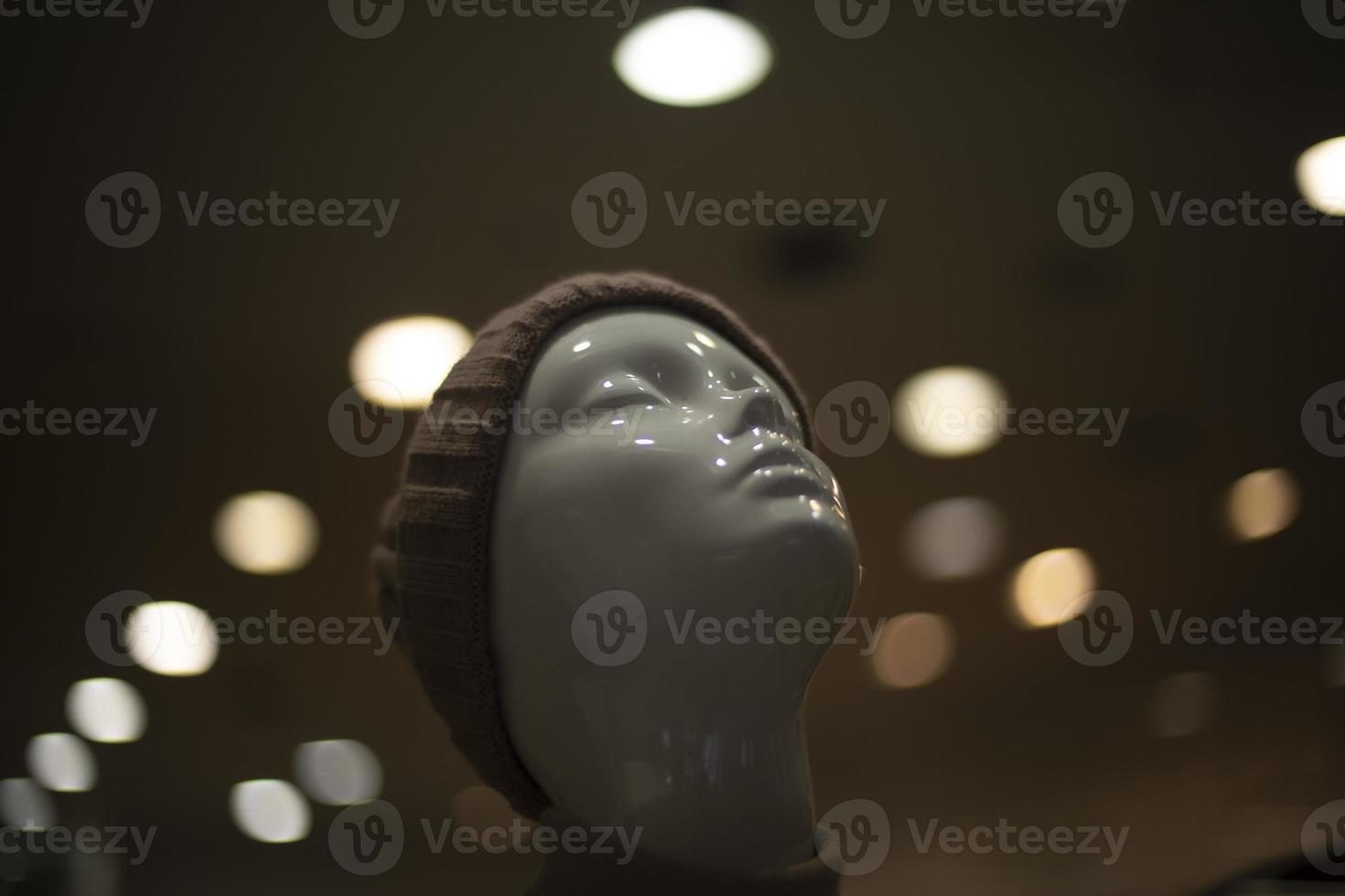 Mannequin in clothing store. Head is made of white plastic. Light on mannequin. photo