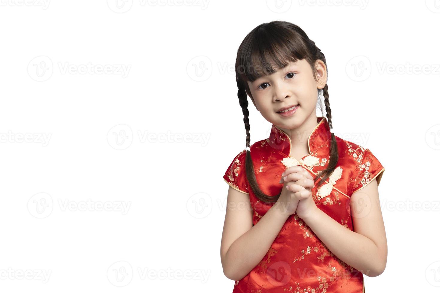 chica asiática en cheongsam con gesto de felicitaciones aislado sobre fondo blanco. feliz Año Nuevo Chino. foto