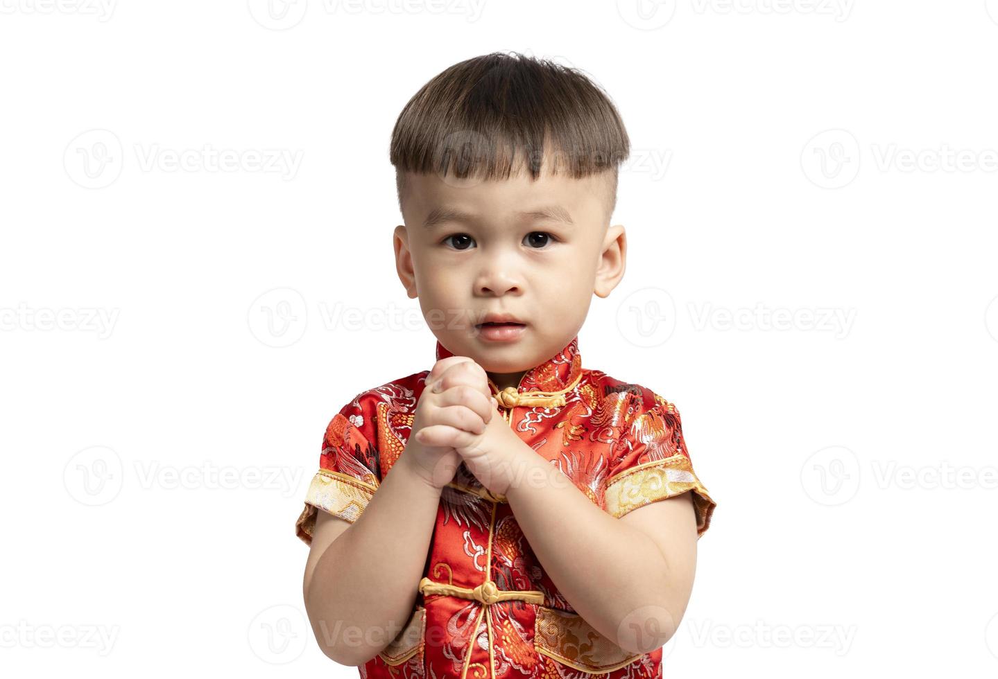 Asian boy in red with congratulations gesture isolated on white background. Happy Chinese New Year. photo