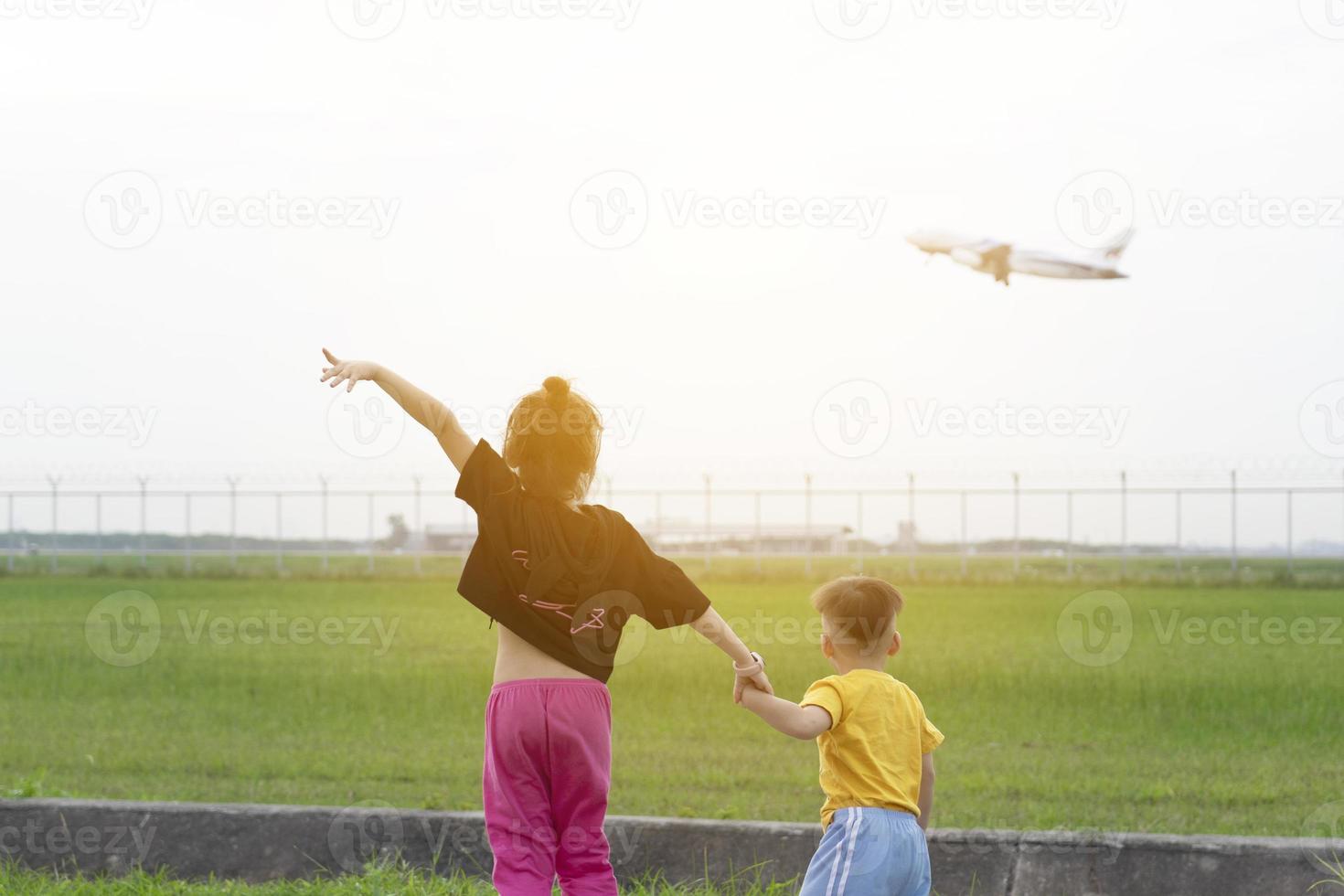 Children watch planes take off and land next to the airport on weekends. photo