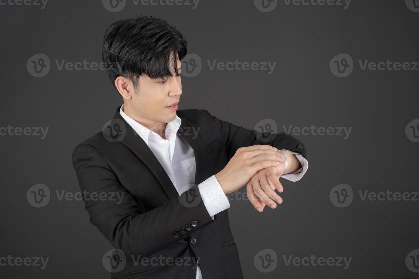 Business man wearing a black suit raising hands doing different gestures. photo