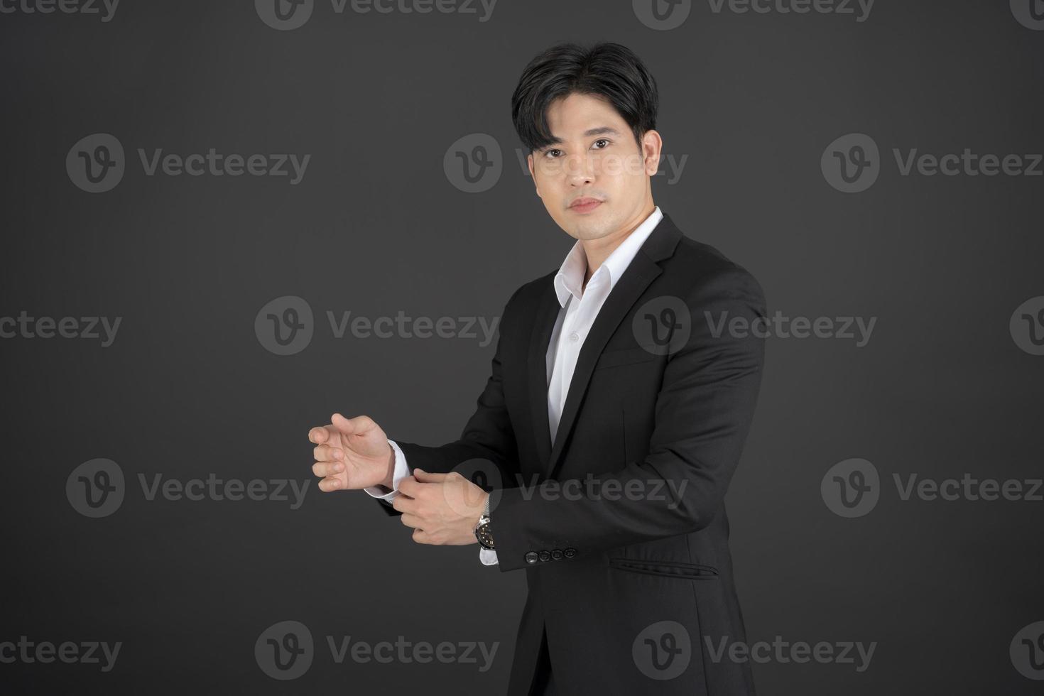 Business man wearing a black suit raising hands doing different gestures. photo