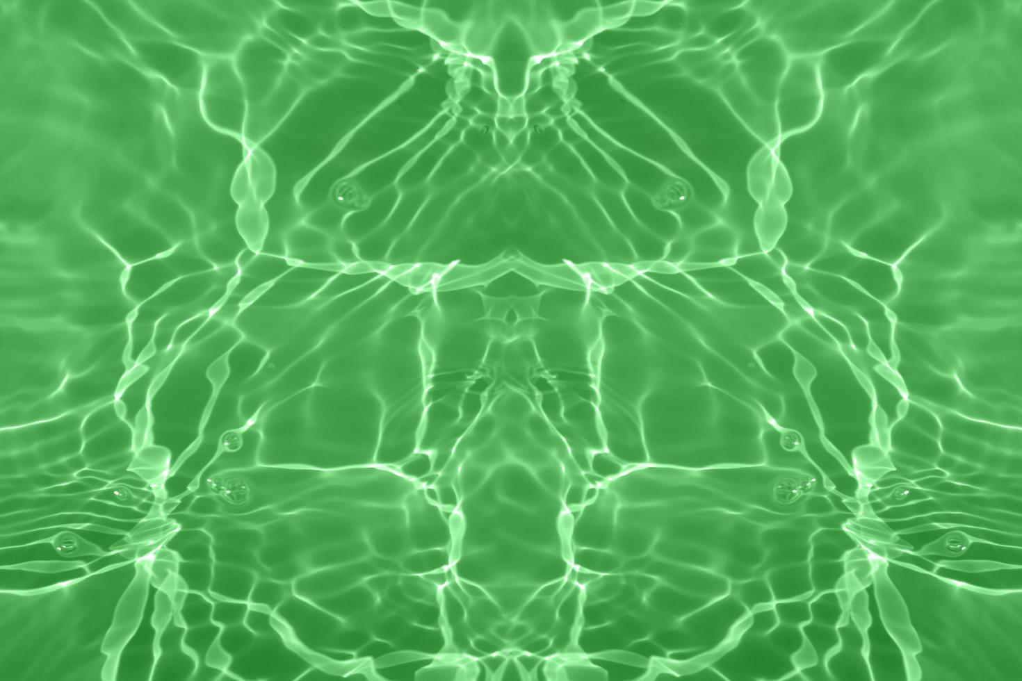 Defocus blurred transparent green colored clear calm water surface texture with splash, bubble. Shining green water ripple background. Surface of water in swimming pool. Green bubble water shining. photo