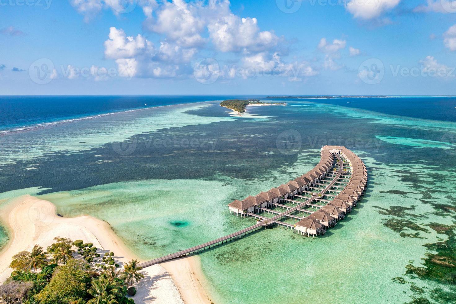 Fantastic aerial island landscape, luxury tropical resort or hotel with water villas and beautiful beach scenery. Amazing bird eyes view in Maldives, landscape seascape aerial view beautiful Maldives photo