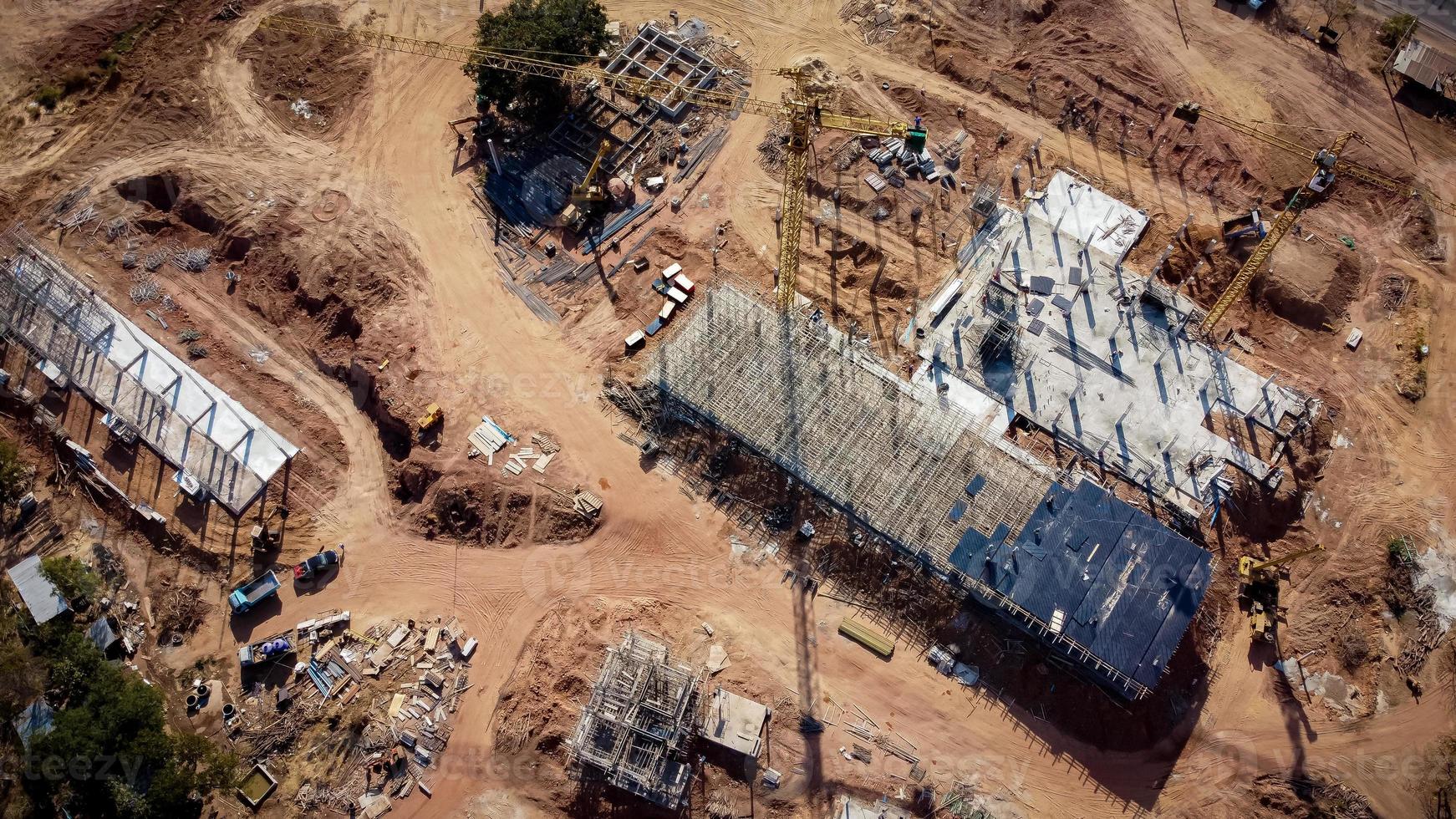 vista aerea el proyecto es la construccion de un gran edificio. grúa de construcción amarilla y trabajadores están trabajando, fotos de drones