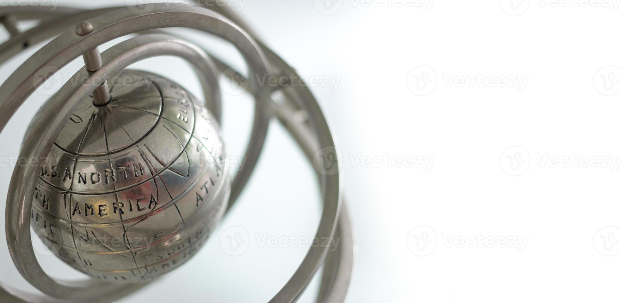 The silver metal globe shows the Americas on a white background. photo