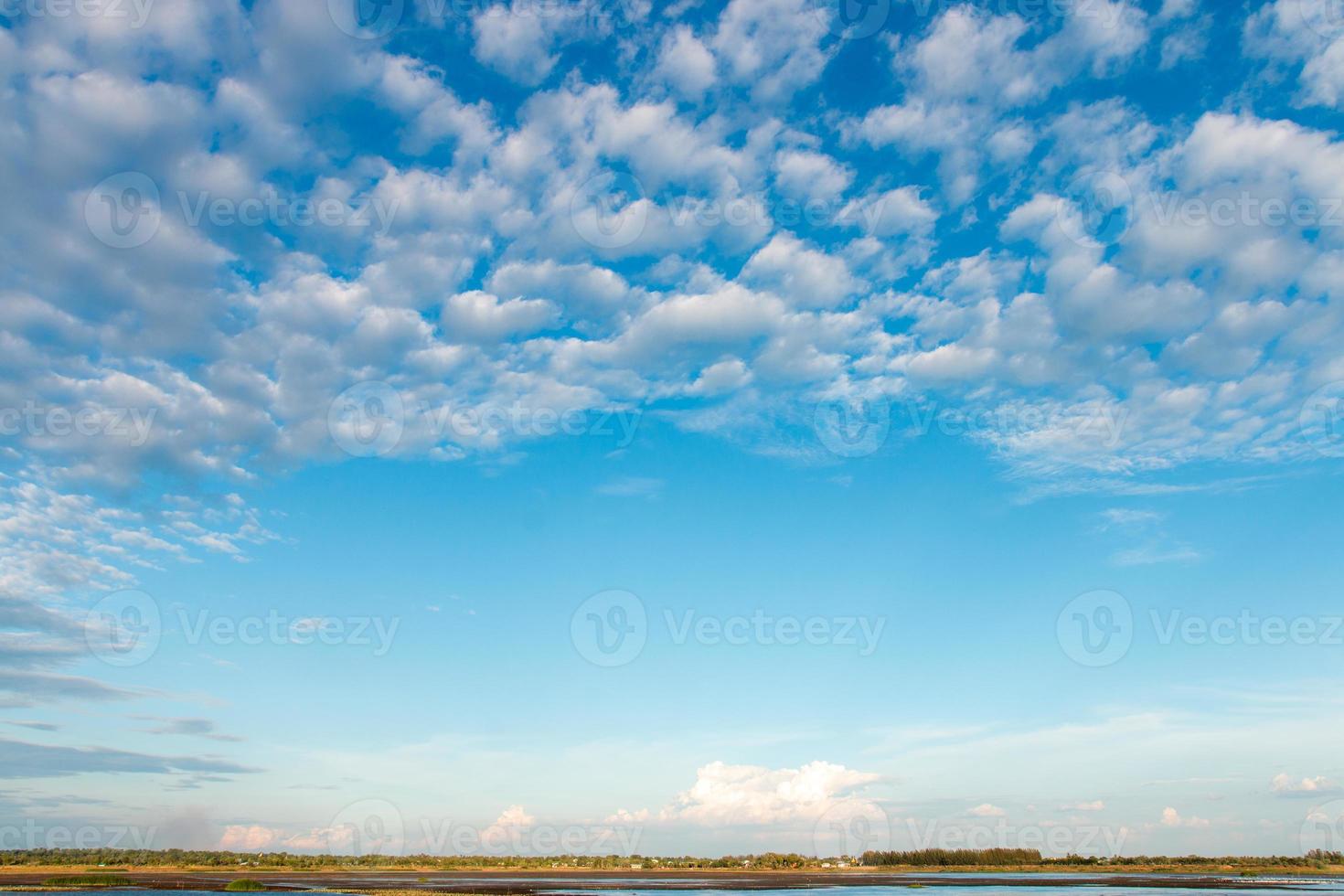 The vast sky is bright blue with many clouds moving. photo