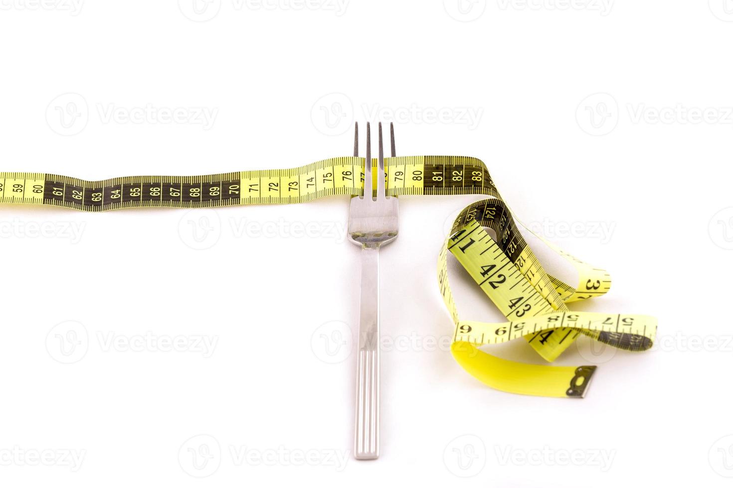 Fork and centimeter tape on a white background, slimming concept photo