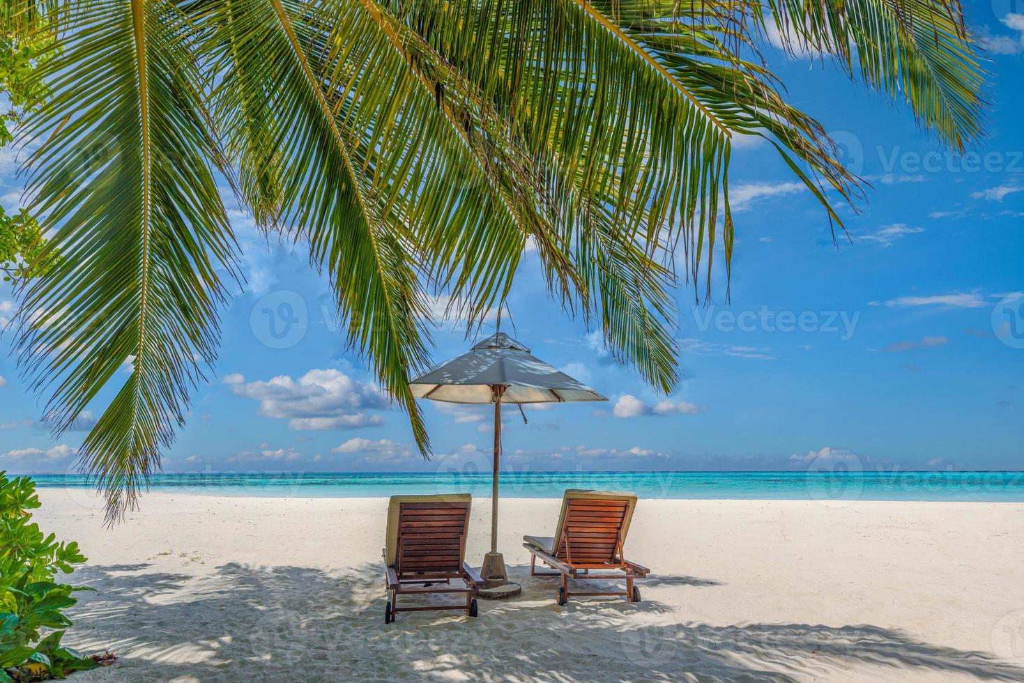 Beautiful tropical island, two chairs, umbrella under palm tree leaves, paradise sea sand sky. Summer travel landscape, vacation beach scenic, idyllic exotic nature closeup of recreation, relaxation. photo