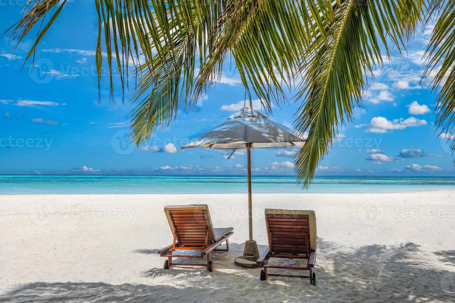 Beautiful tropical island, two chairs, umbrella under palm tree leaves, paradise sea sand sky. Summer travel landscape, vacation beach scenic, idyllic exotic nature closeup of recreation, relaxation. photo