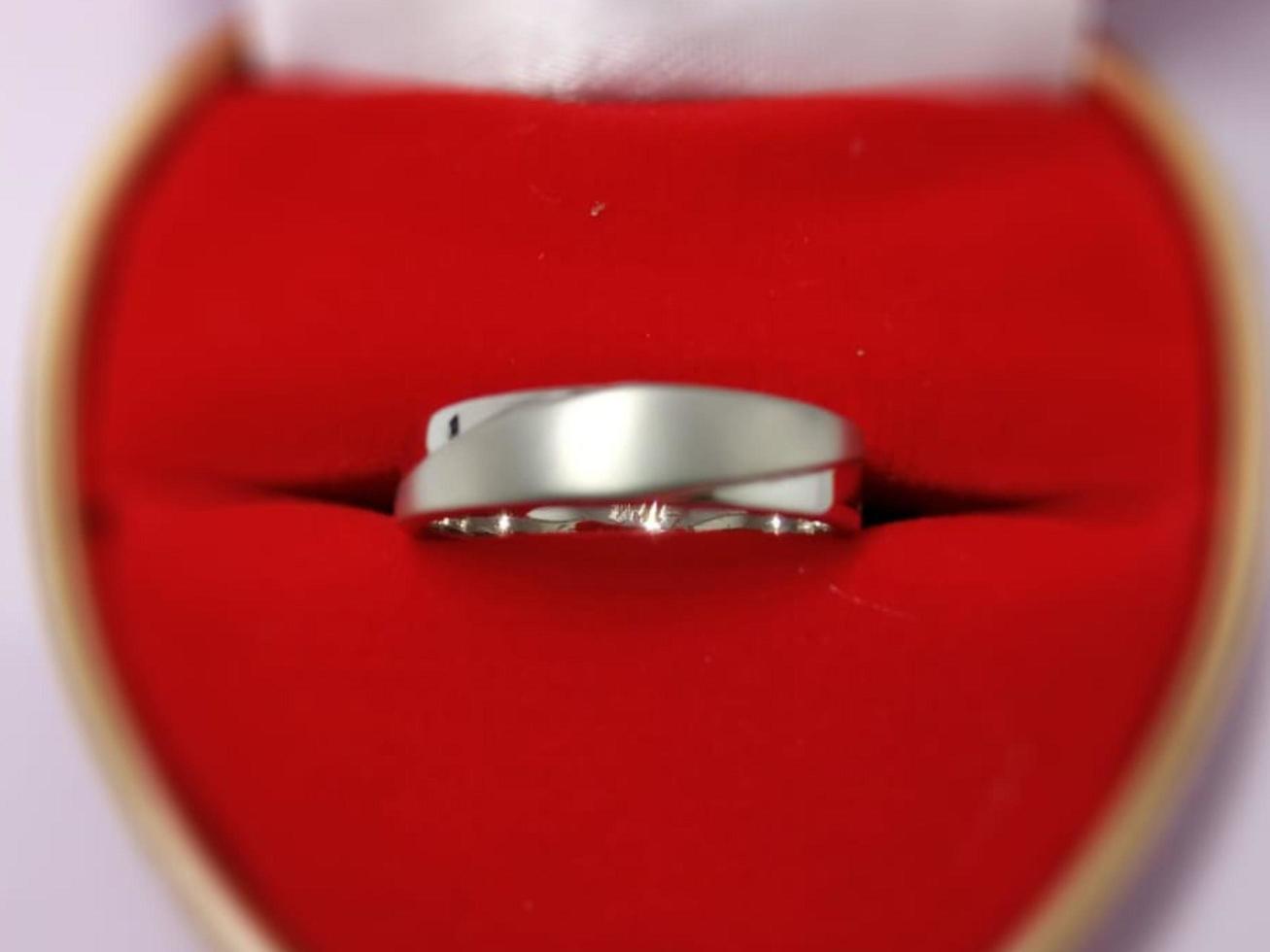 anillos de boda y anillos de compromiso hechos de titanio con un fondo de caja de anillo rojo foto