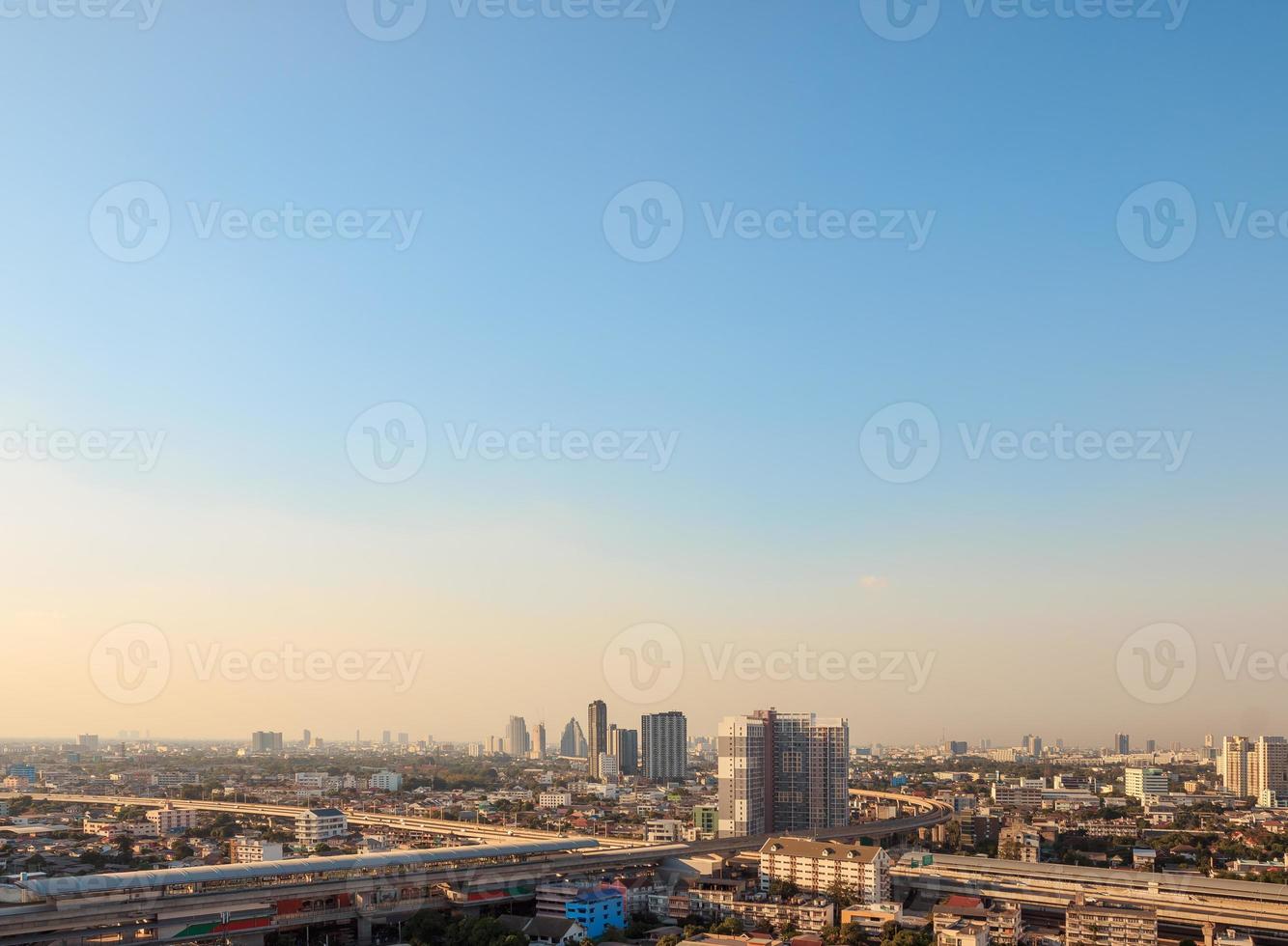 Aerial view of the metropolis at sunset sky, Buildings, roads and electric train routes. photo