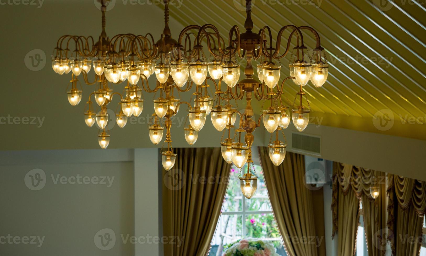 Orange light chandeliers installed on the ceiling of the hotel banquet hall. photo