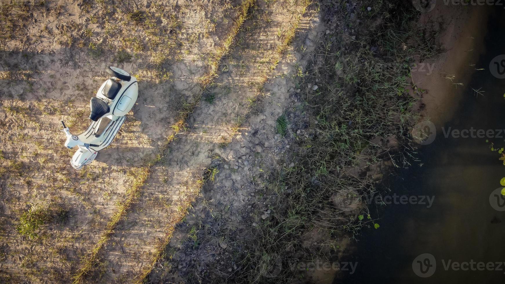 Aerial view, White vintage scooter park near the lake at sunset. photo