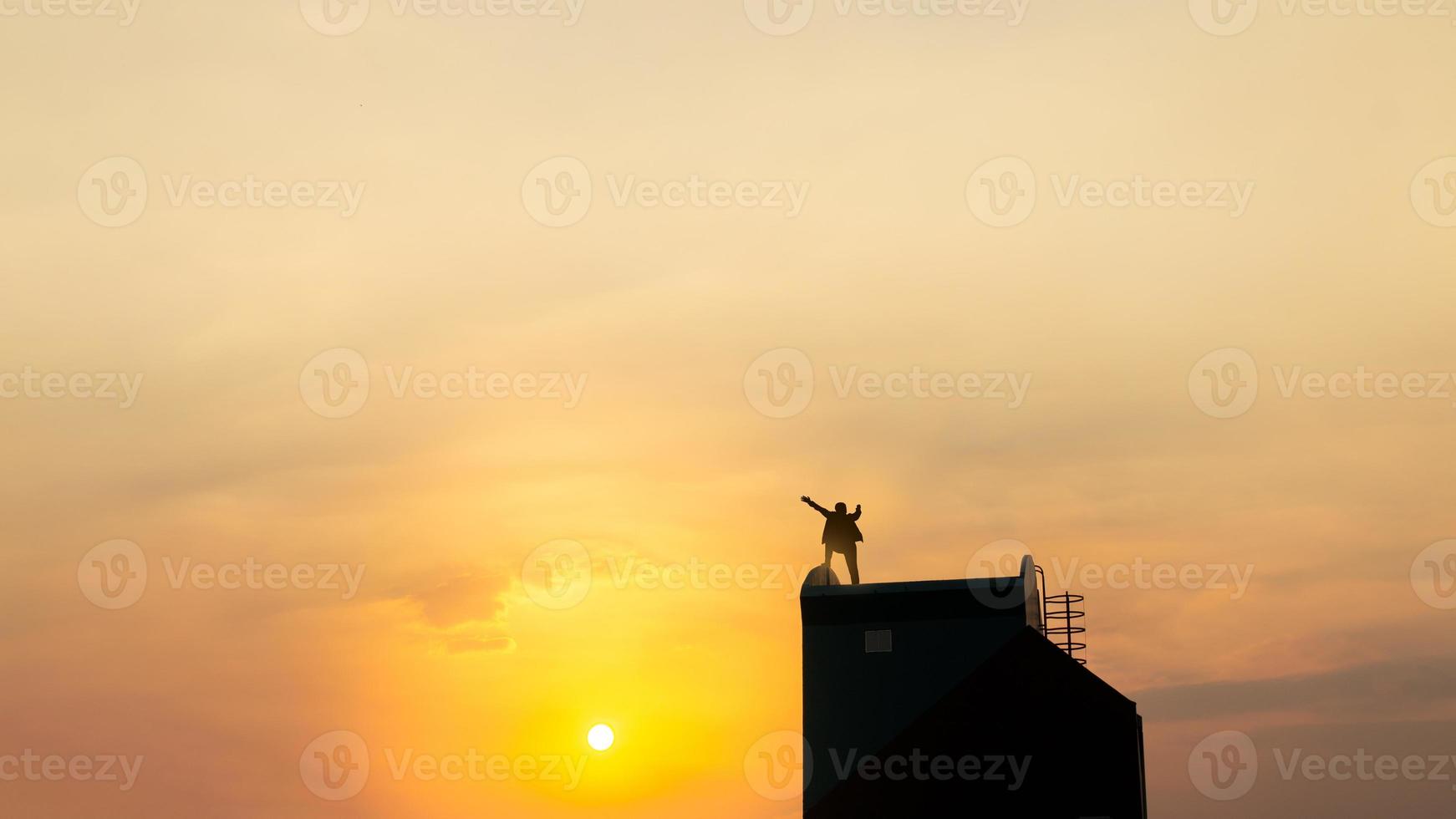 silueta de hombre en rofftop sobre cielo y fondo de luz solar, negocios, éxito, liderazgo, logro y concepto de personas foto