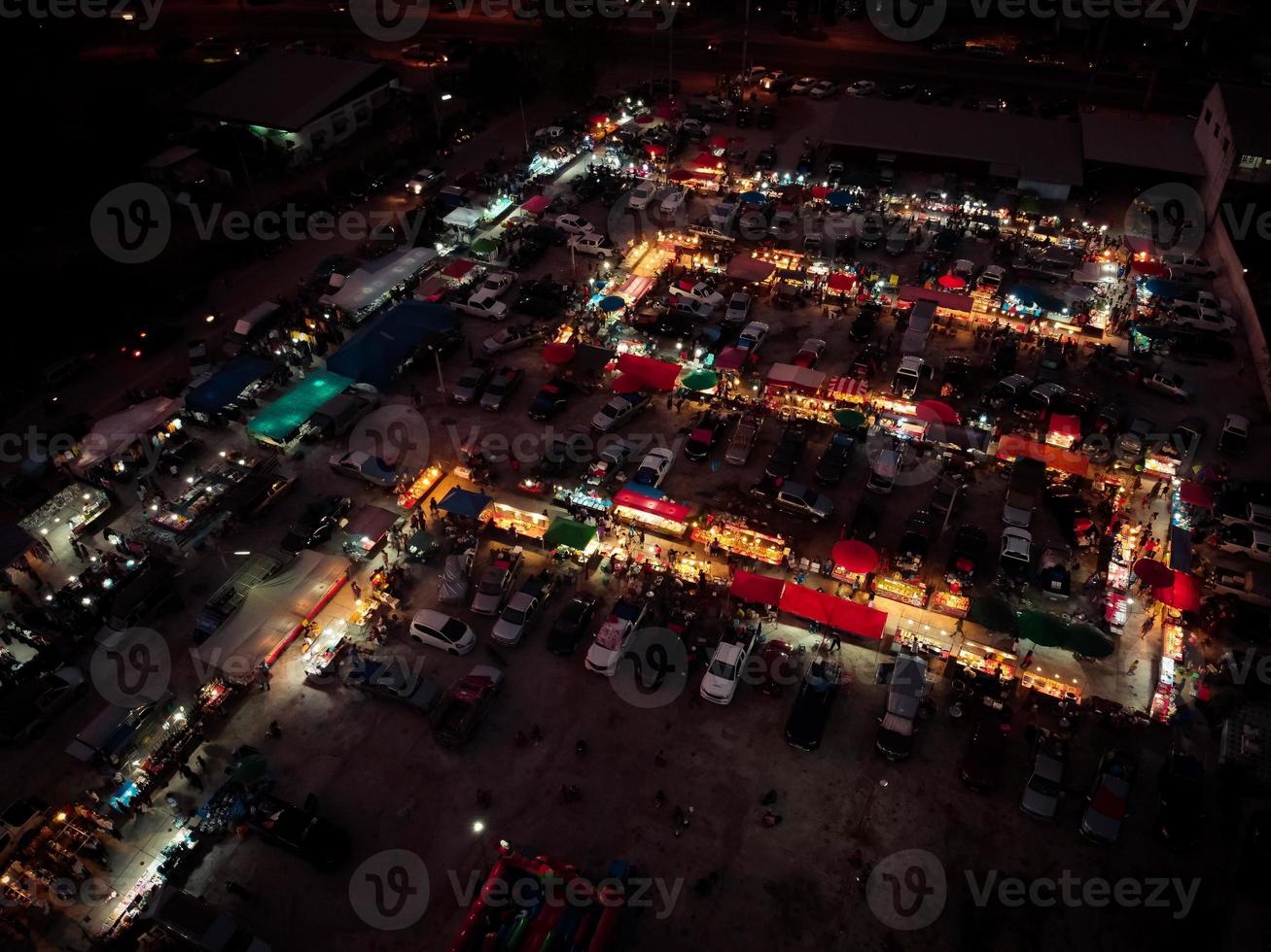 vista aérea en el mercado nocturno. hay mucha gente, coches y tiendas. foto