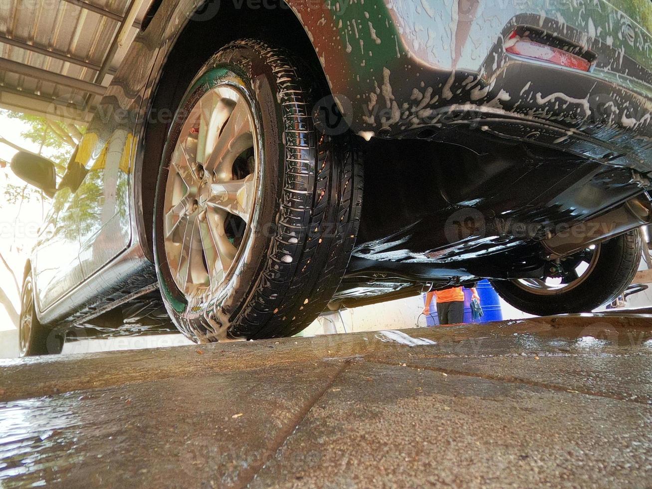lavado de autos con vista de ángulo bajo con espuma para limpiar la suciedad y mantener la salud del conductor y los pasajeros. foto