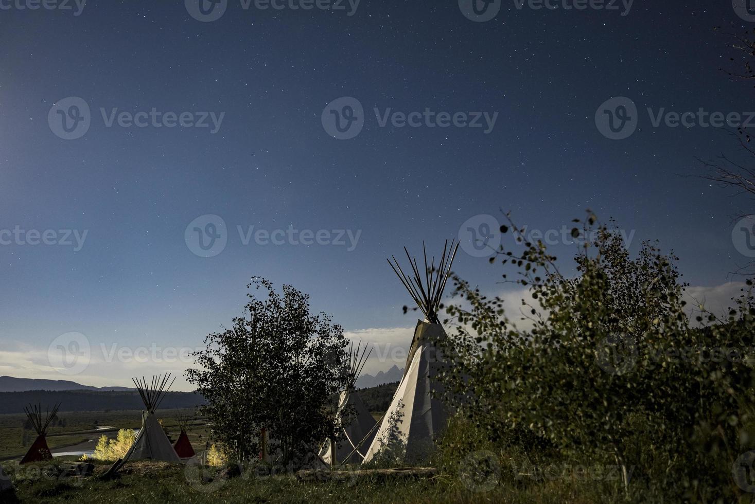 pequeñas yurtas de pie en el campo bajo el cielo nocturno lleno de estrellas. pasar la noche bajo las estrellas. foto