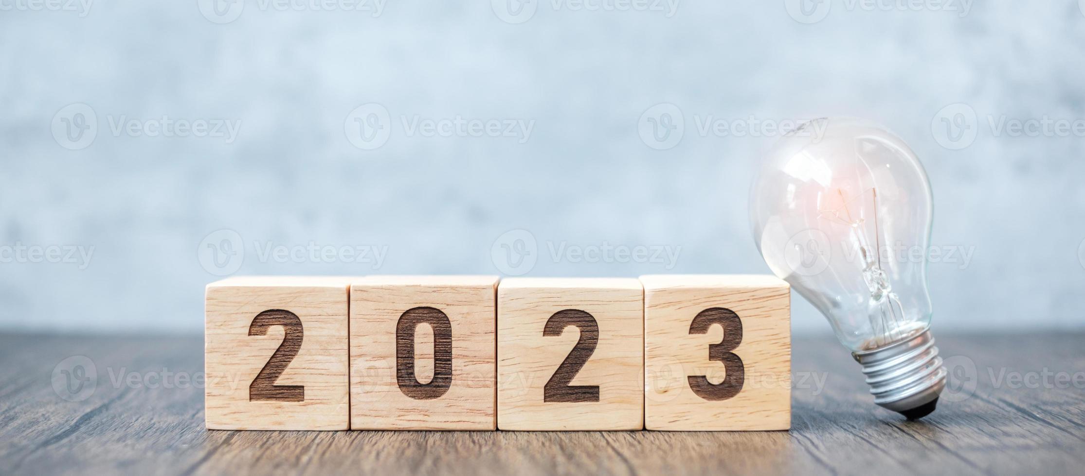 Bloque 2023 con bombilla. idea de negocio, creatividad, pensamiento, lluvia de ideas, objetivo, resolución, estrategia, plan, acción, cambio y conceptos de inicio de año nuevo foto