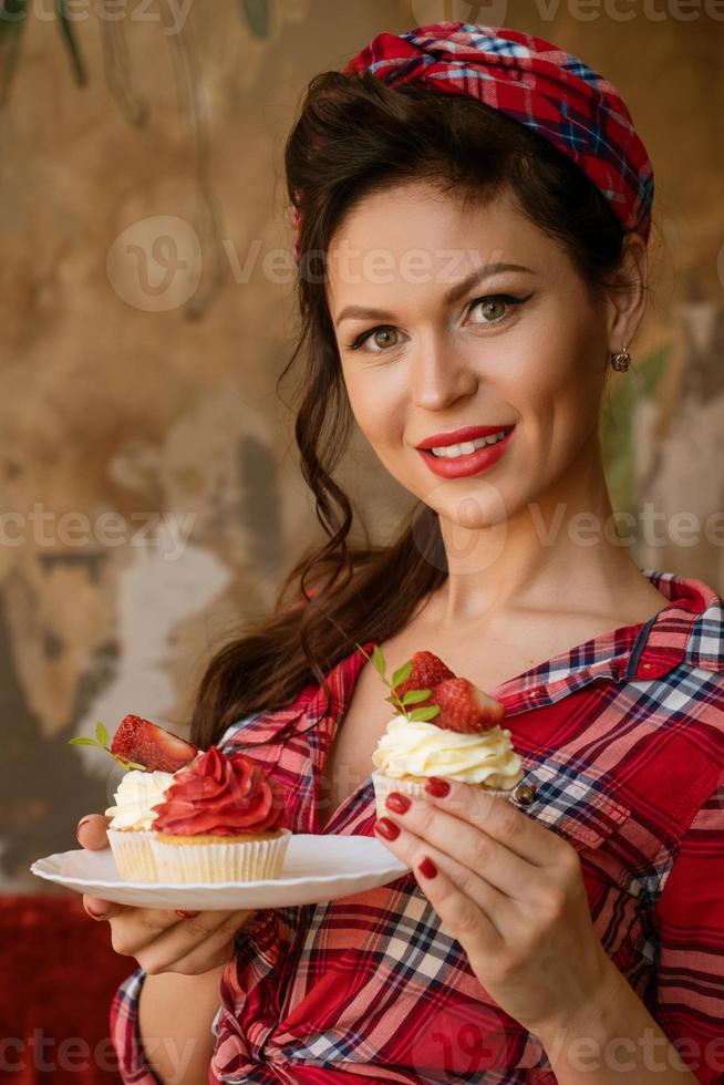 beautiful woman with makeup is holding a cake with strawberries photo