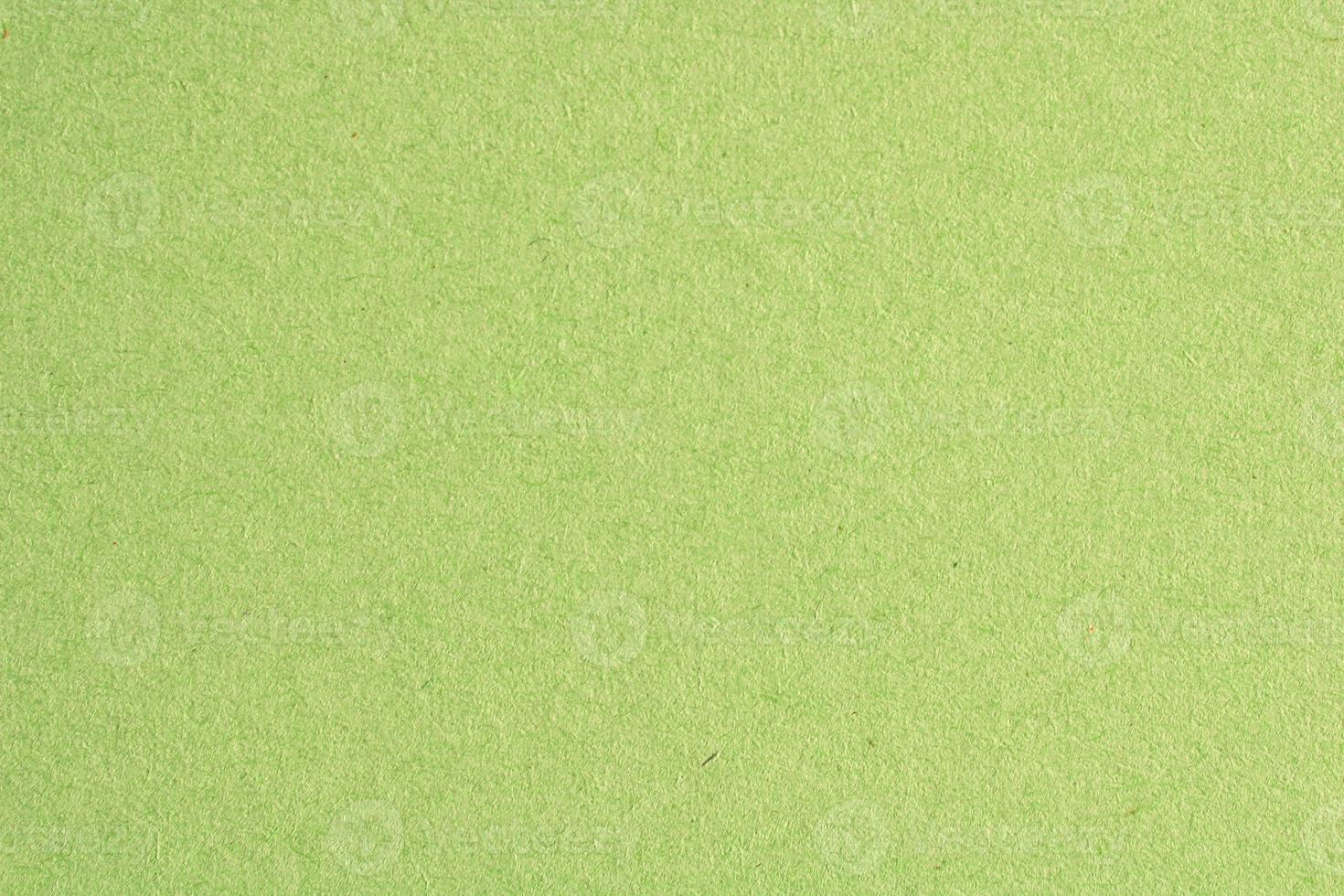 Abstract design background green recycled natural paper texture. Old fiber uneven, rough cardboard sheet seamless spotted surface pattern. Close-up, mock up, top view with copy space for text photo