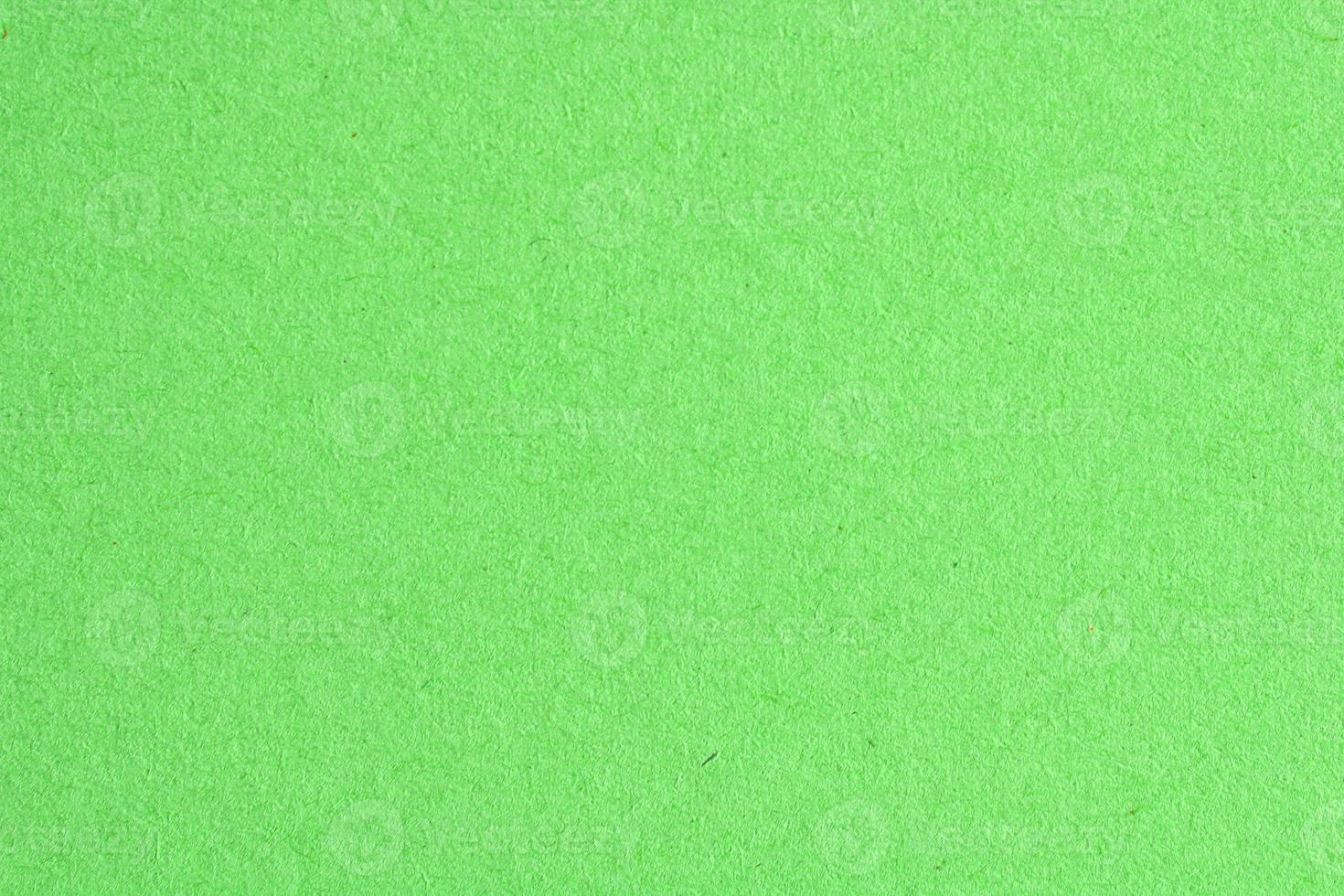 Abstract design background neon green recycled natural paper texture. Old fiber uneven, rough cardboard sheet seamless spotted surface pattern. Close-up, mock up, top view with copy space for text photo