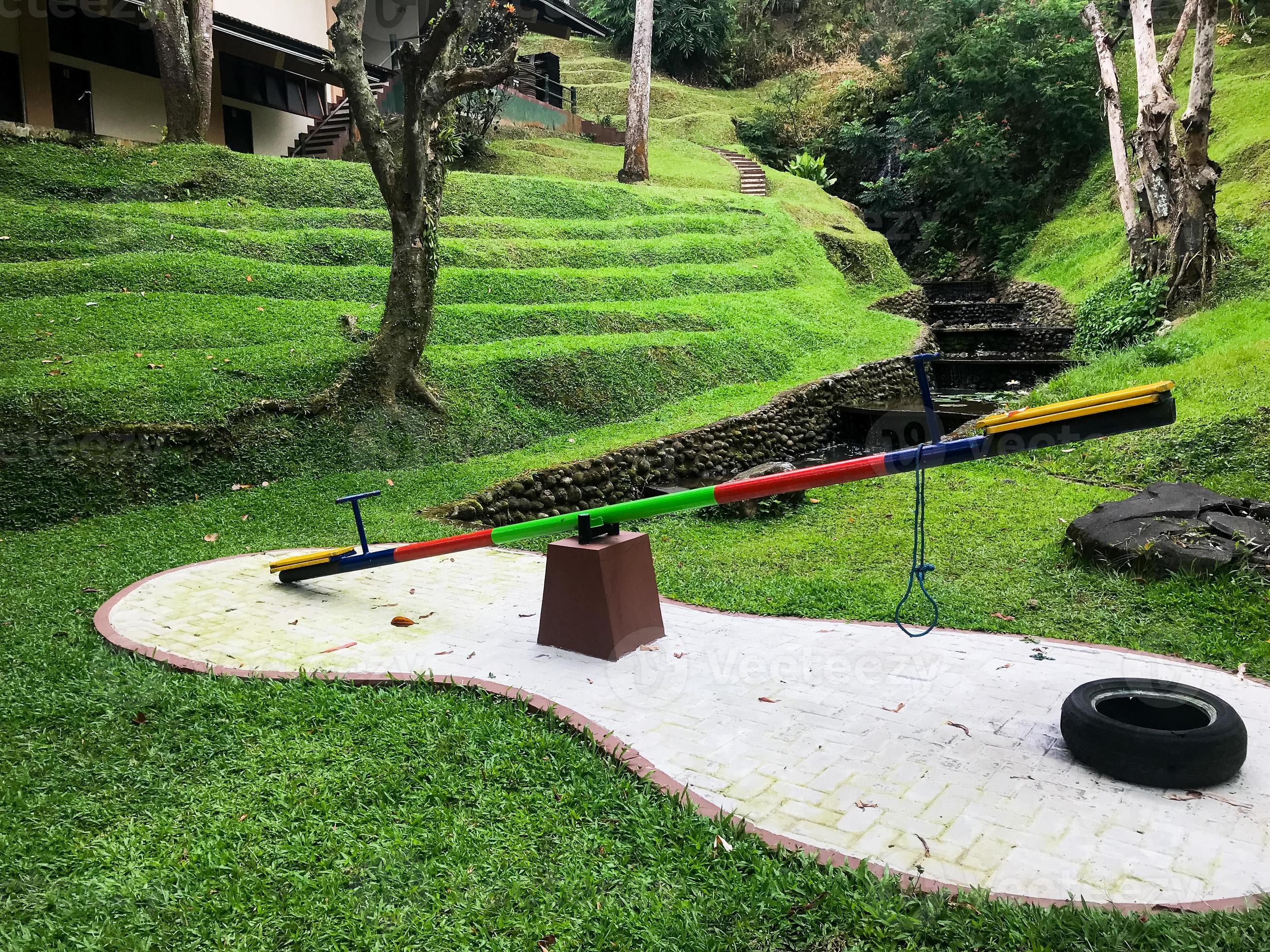 Empty seesaw on playground in public park. Wooden seesaw in the park