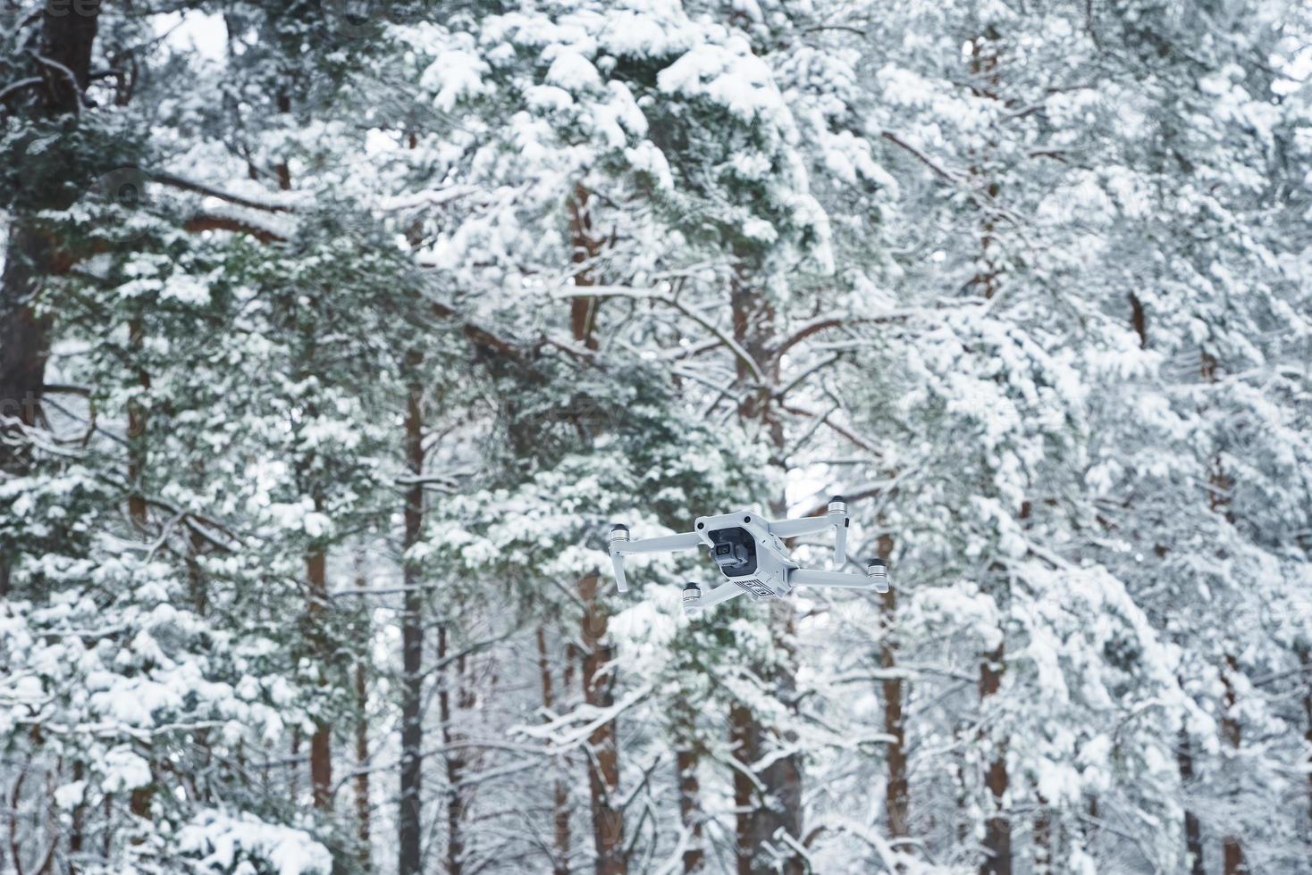 Drone flying in winter forest photo