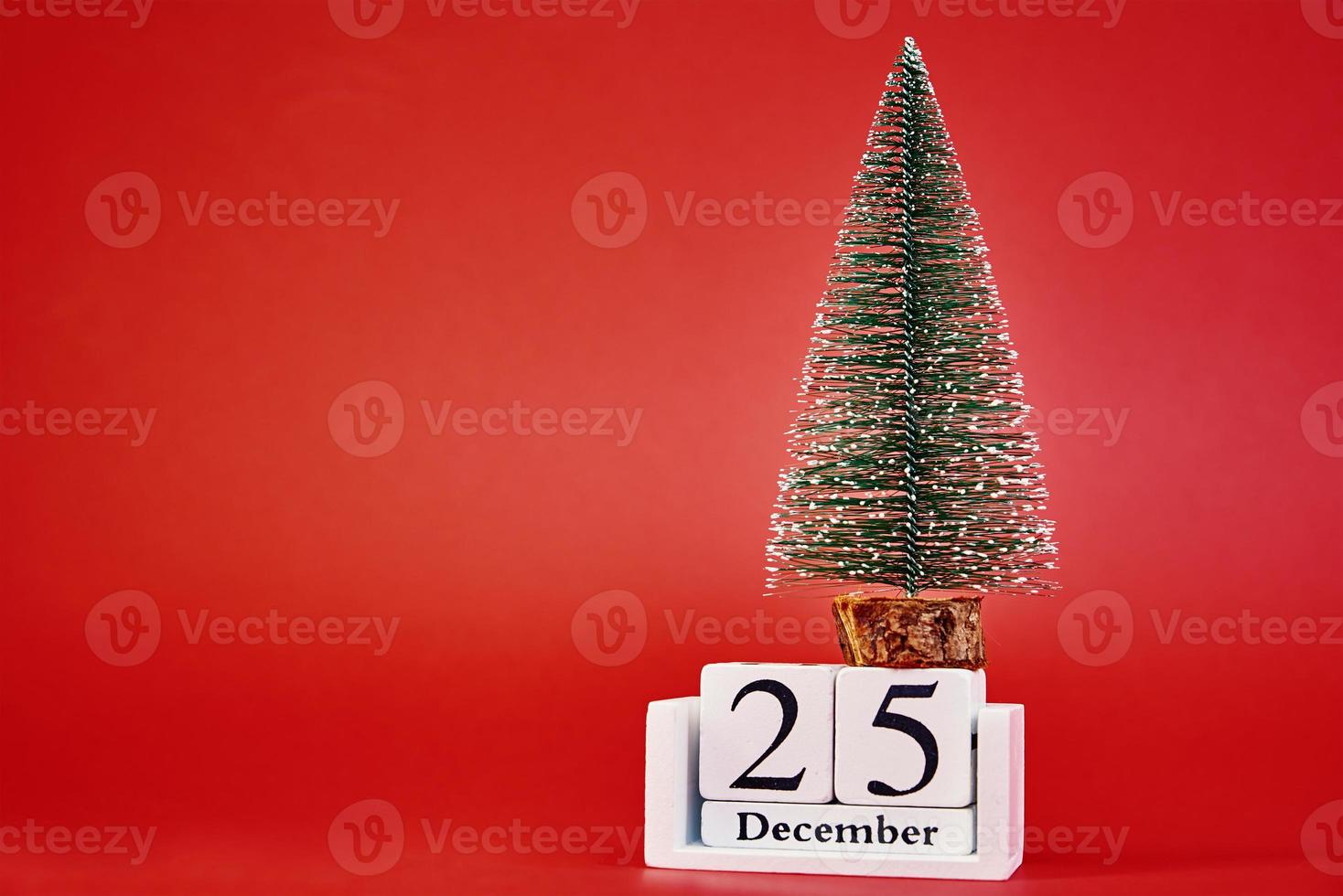 Merry Christmas and Happy New Year composition with christmas tree on red background photo