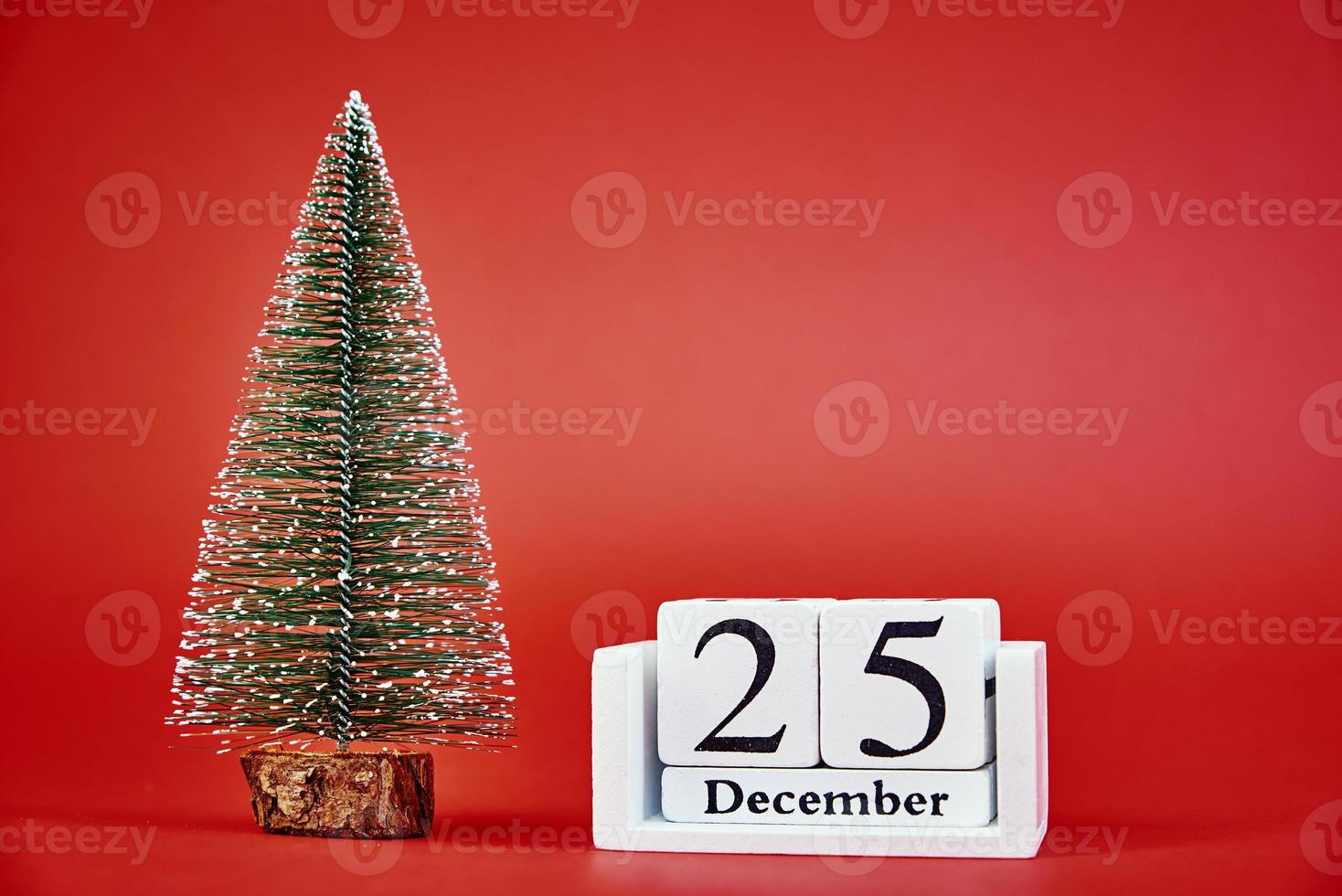 feliz navidad y feliz año nuevo composición con árbol de navidad sobre fondo rojo foto