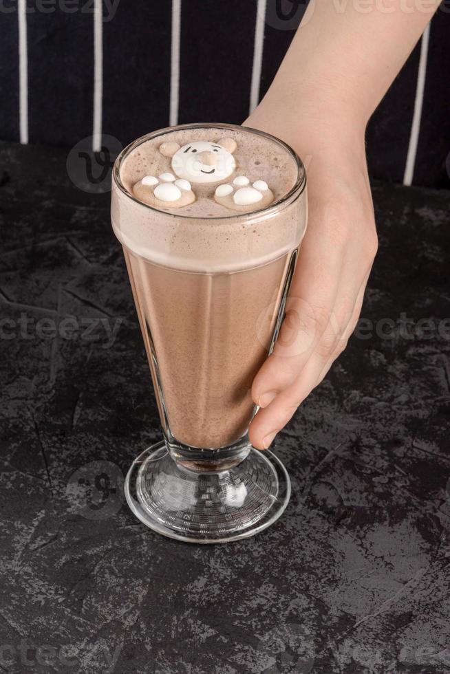 cocoa drink decorated with funny cookies on a dark background photo