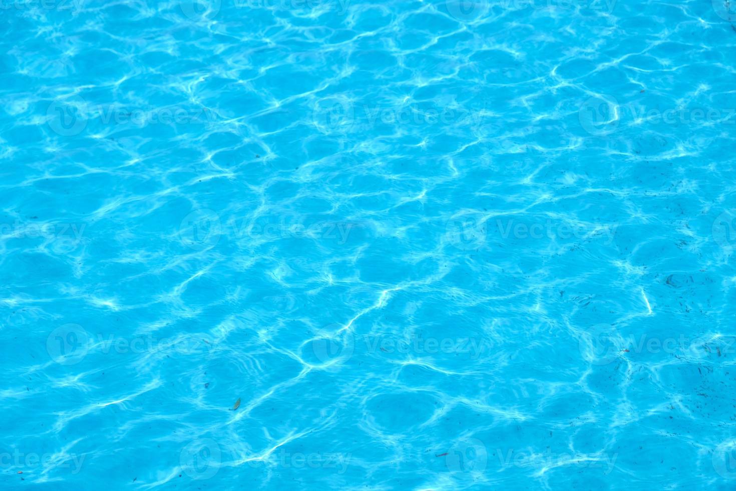 el viento hace ondular el agua. piscina azul que refleja el sol ondulado. basura en el fondo de la piscina, fondo azul sucio de la piscina. foto