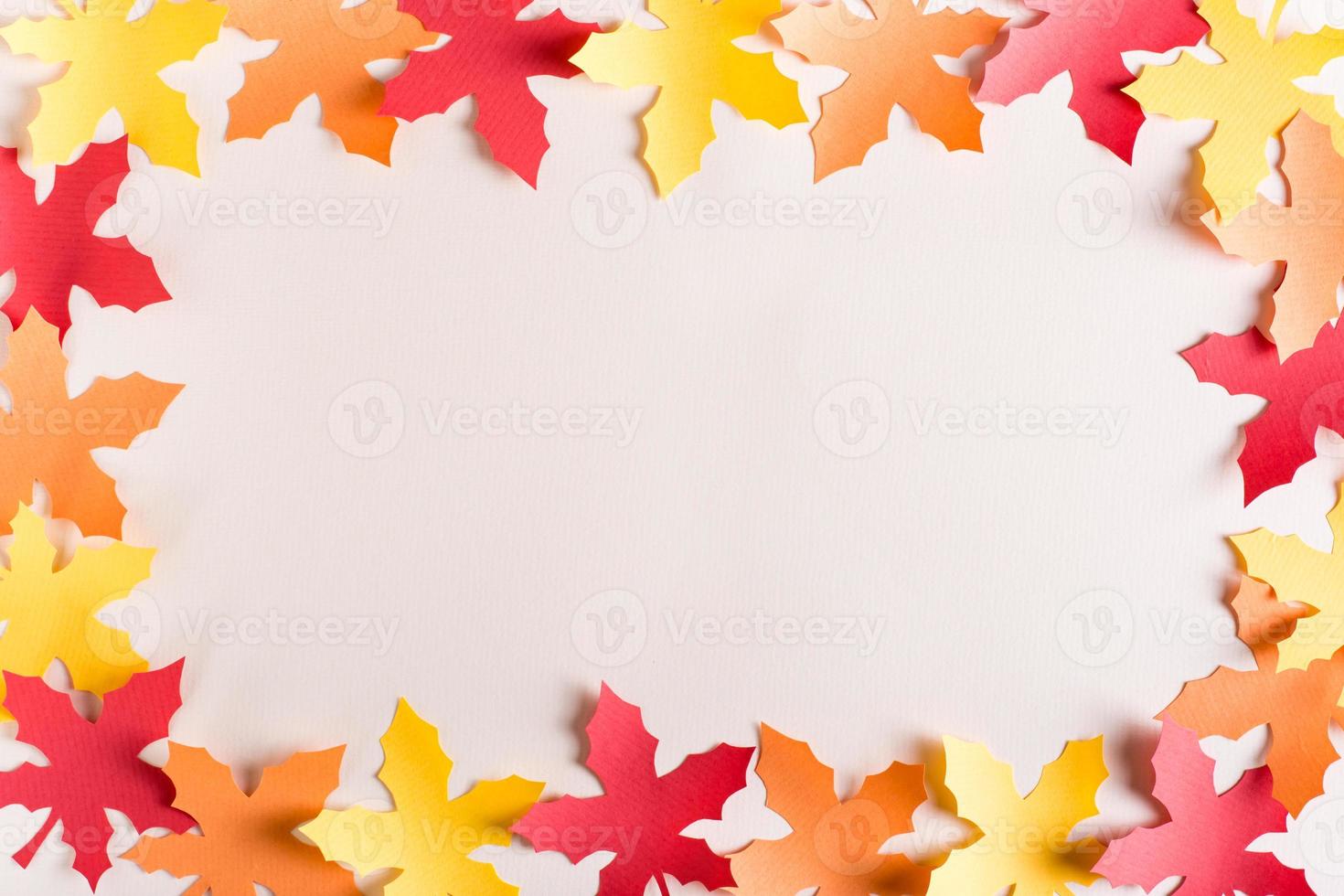 Frame made of cut out maple multi-colored leaves from craft paper. Autumn decoration. photo
