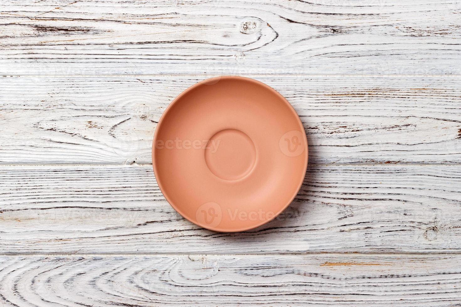 empty orange matte plate on wooden background photo