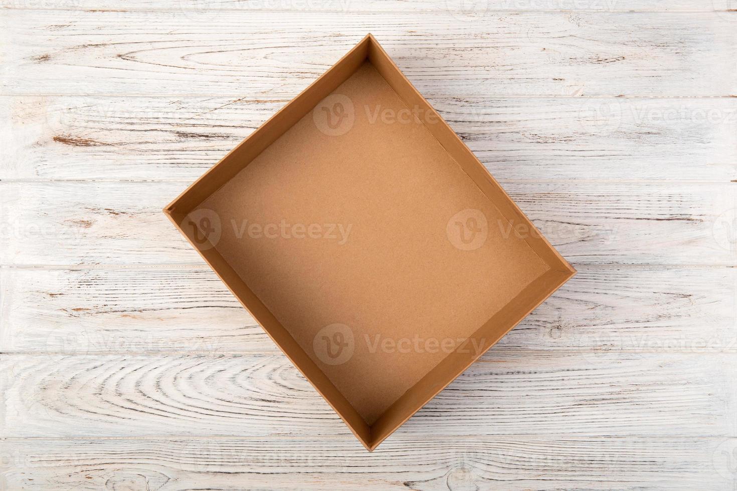 Empty Cardboard box on a white wooden background top view photo