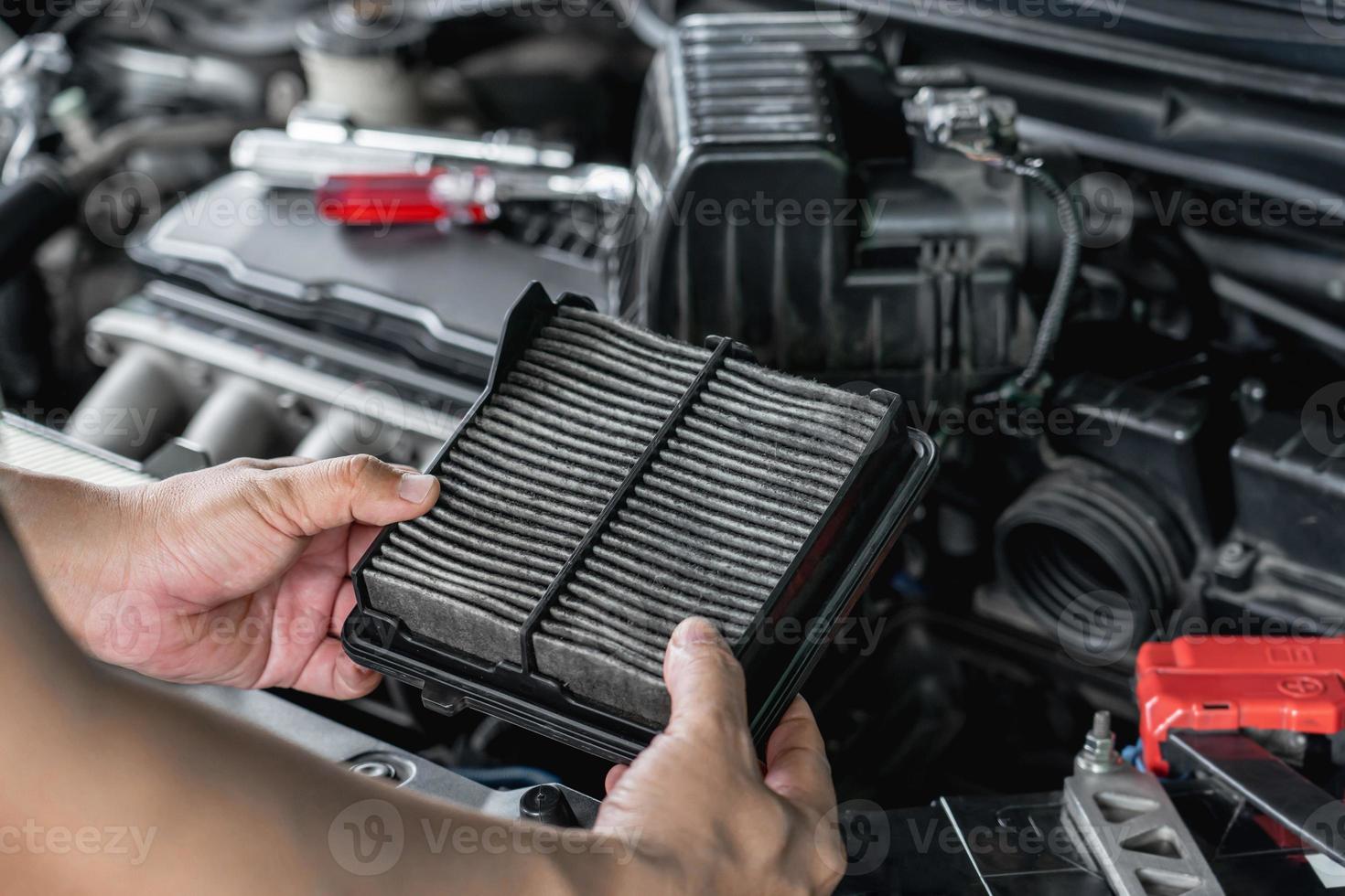 entregue a un hombre que sostiene una nueva parte del filtro de aire del cambio del motor del automóvil y verifique el automóvil en el concepto de servicio básico de la sala de máquinas foto