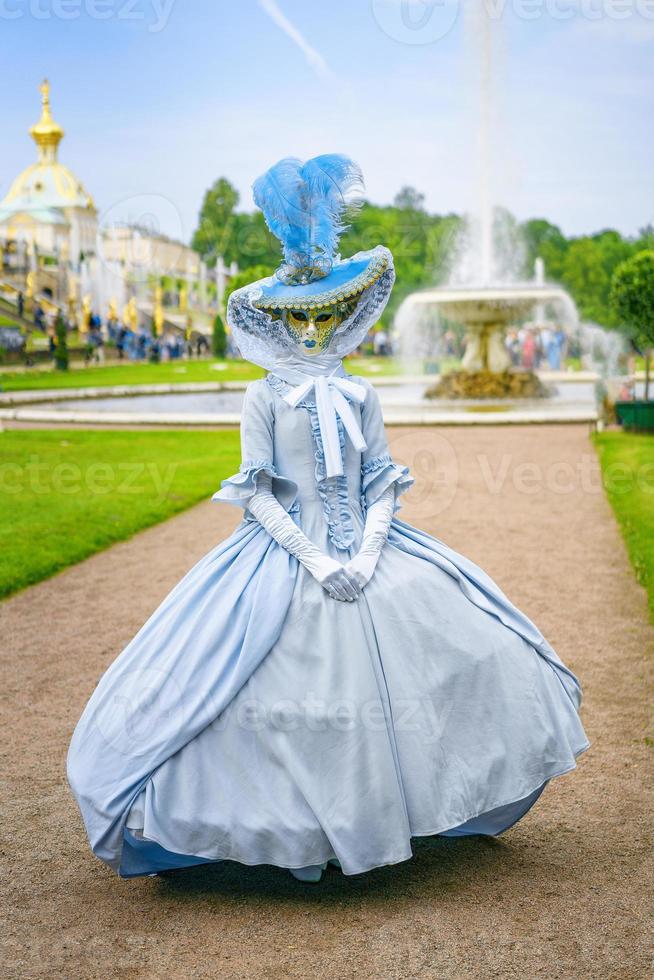 young woman in dress and Venetian mask photo